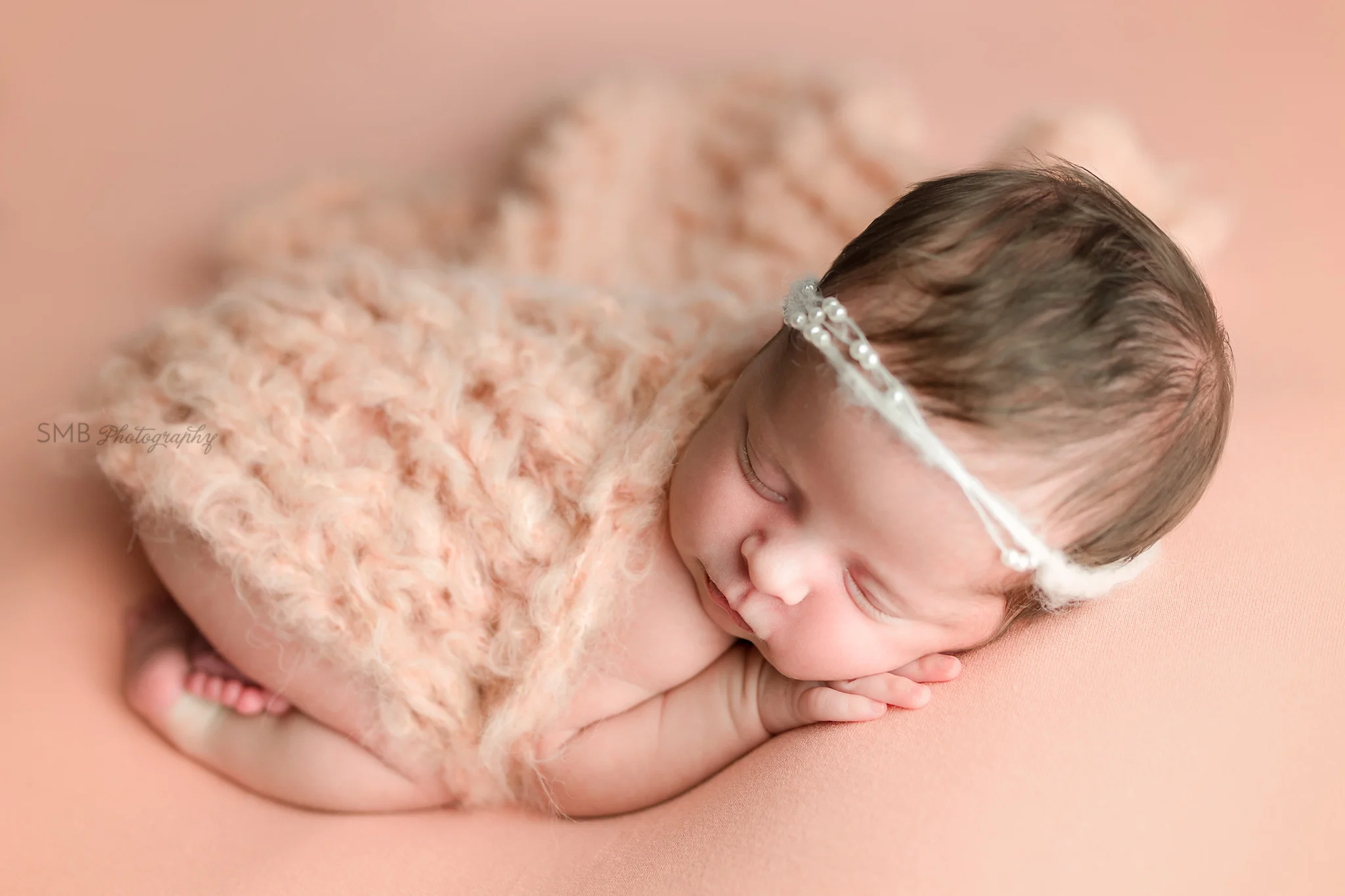 Baby girl sleeping covered in peach wisp layer