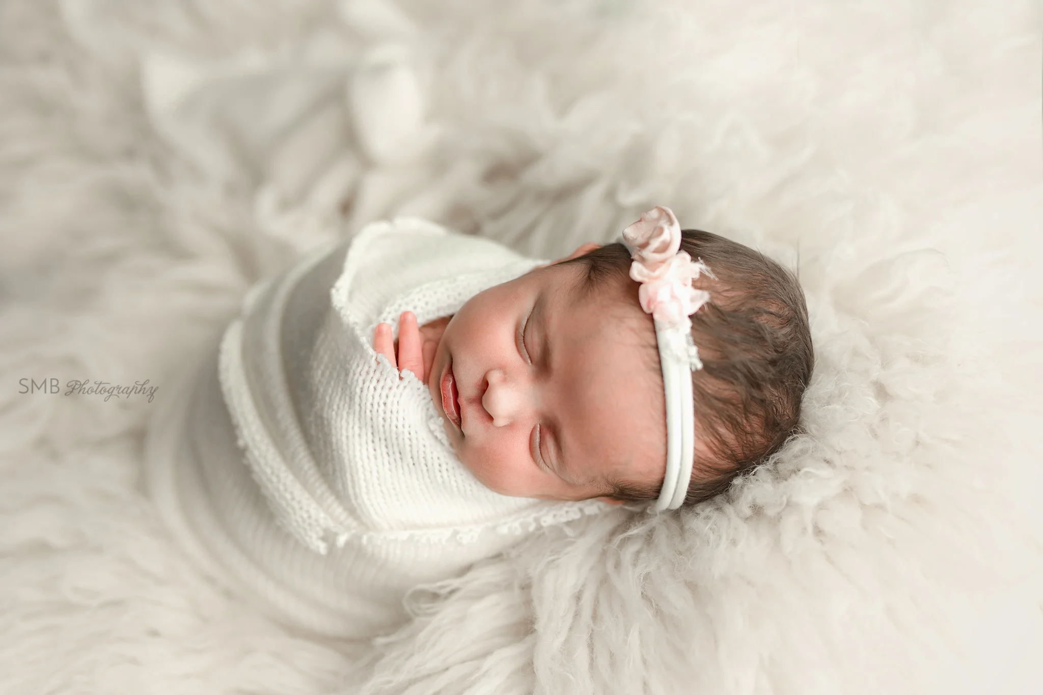 Baby girl sleeping on white fur
