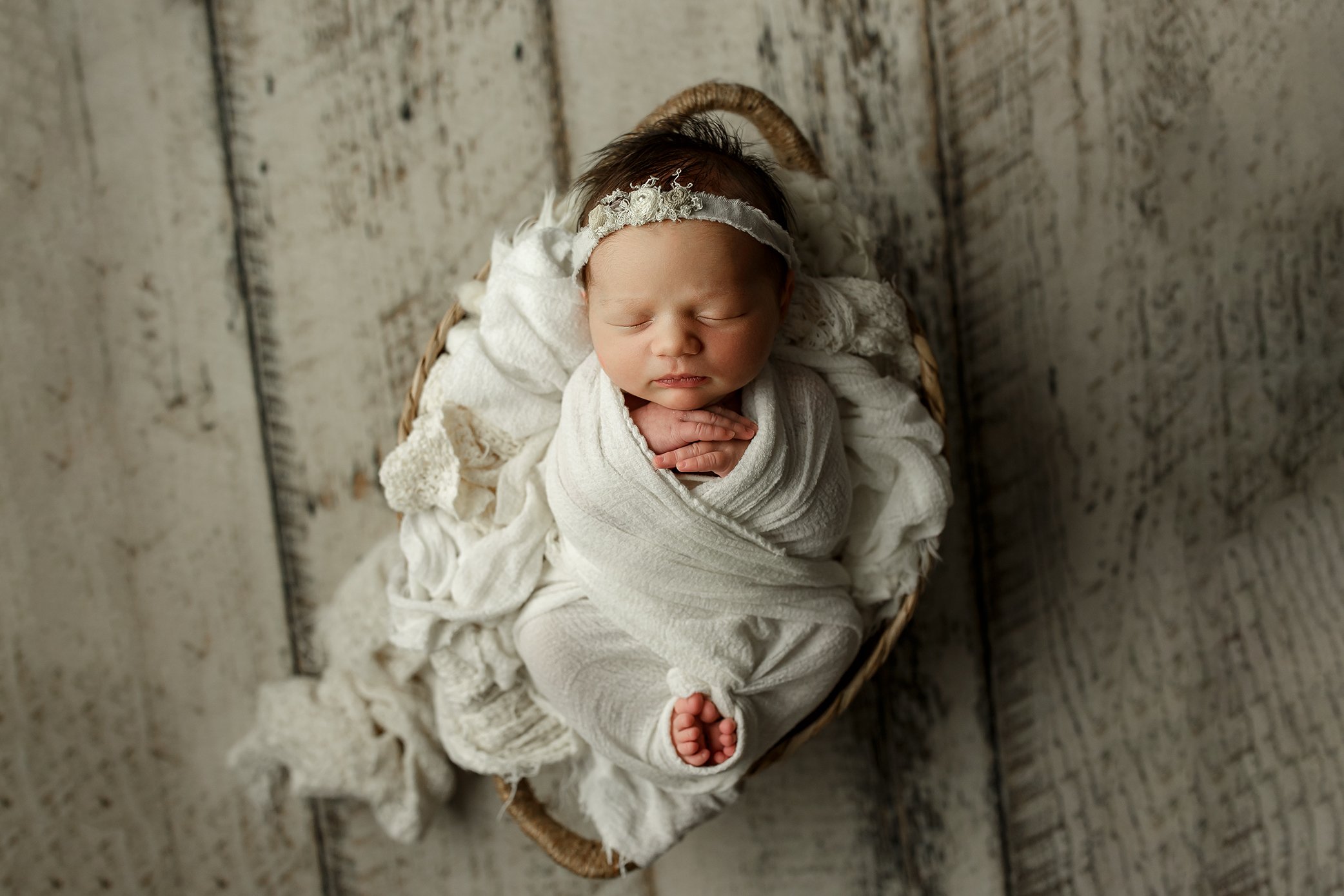 Baby girl wrapped in white with her toes out