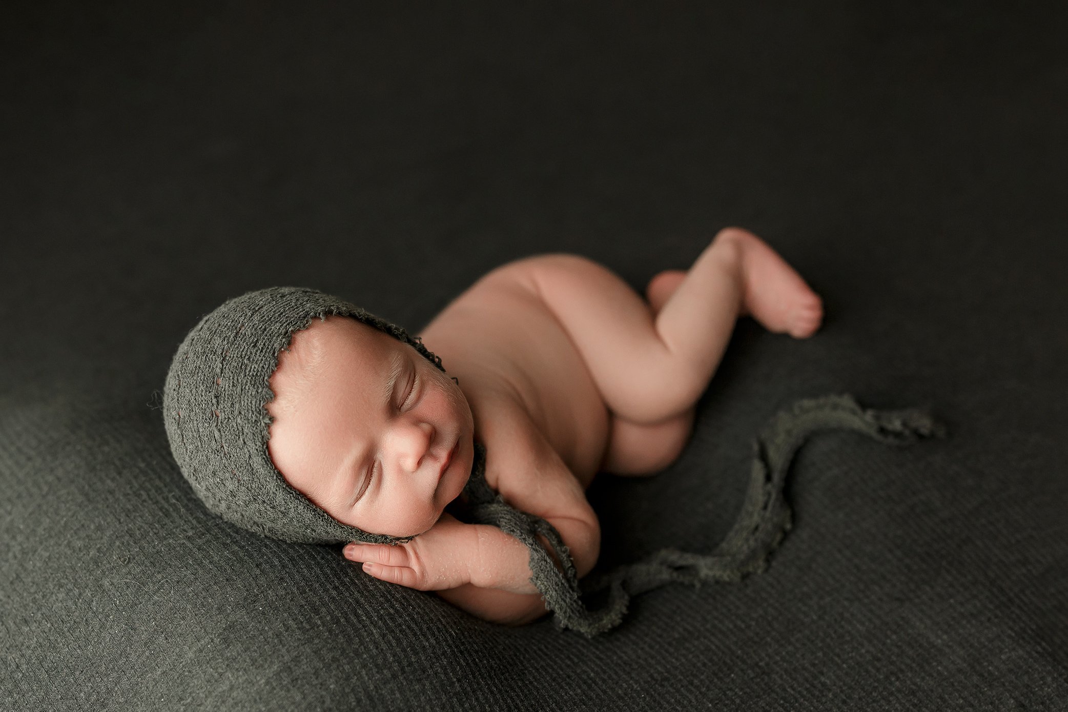 Newborn baby boy wearing green bonnet