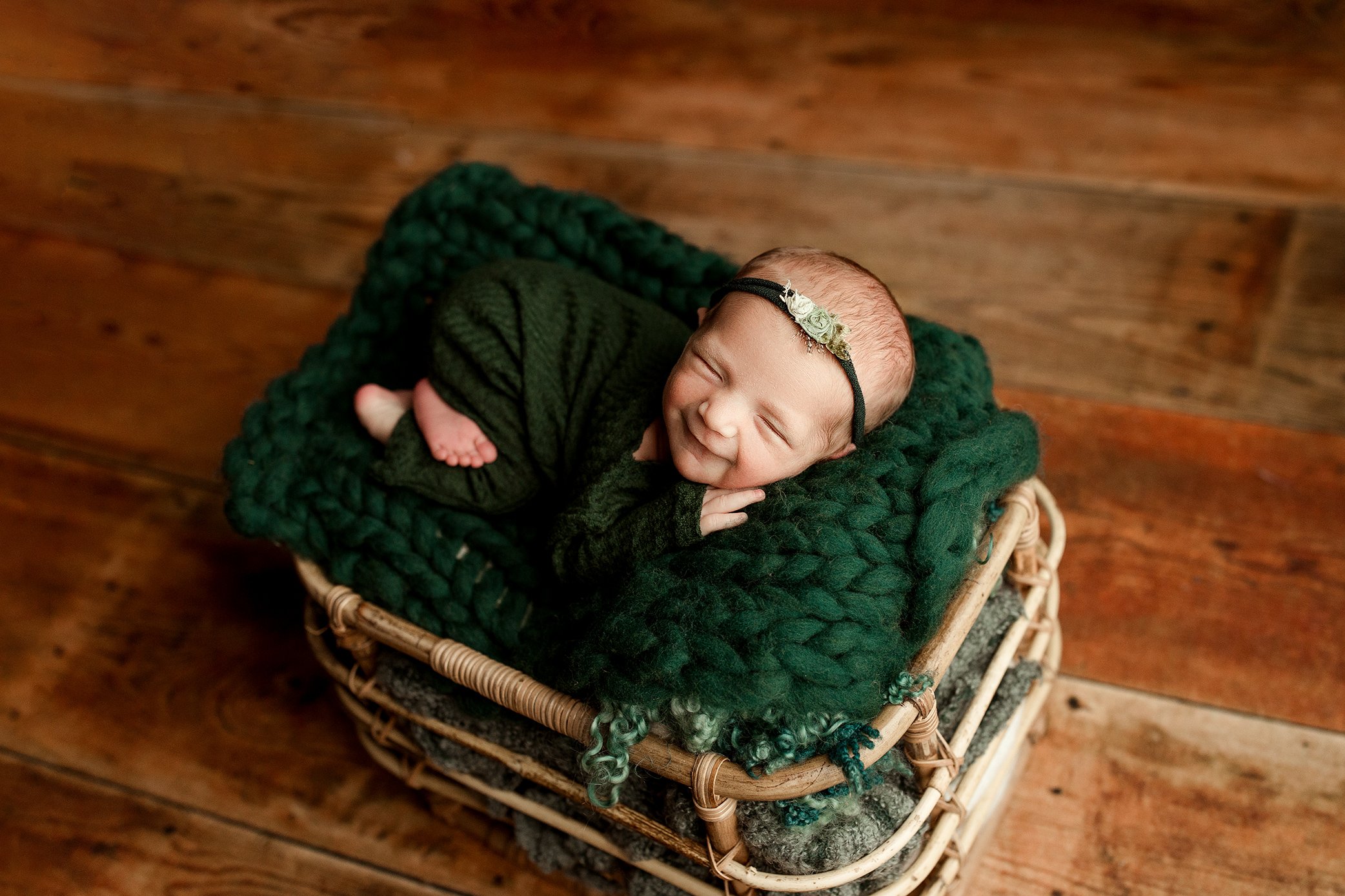 Newborn baby girl smiling in green outfit