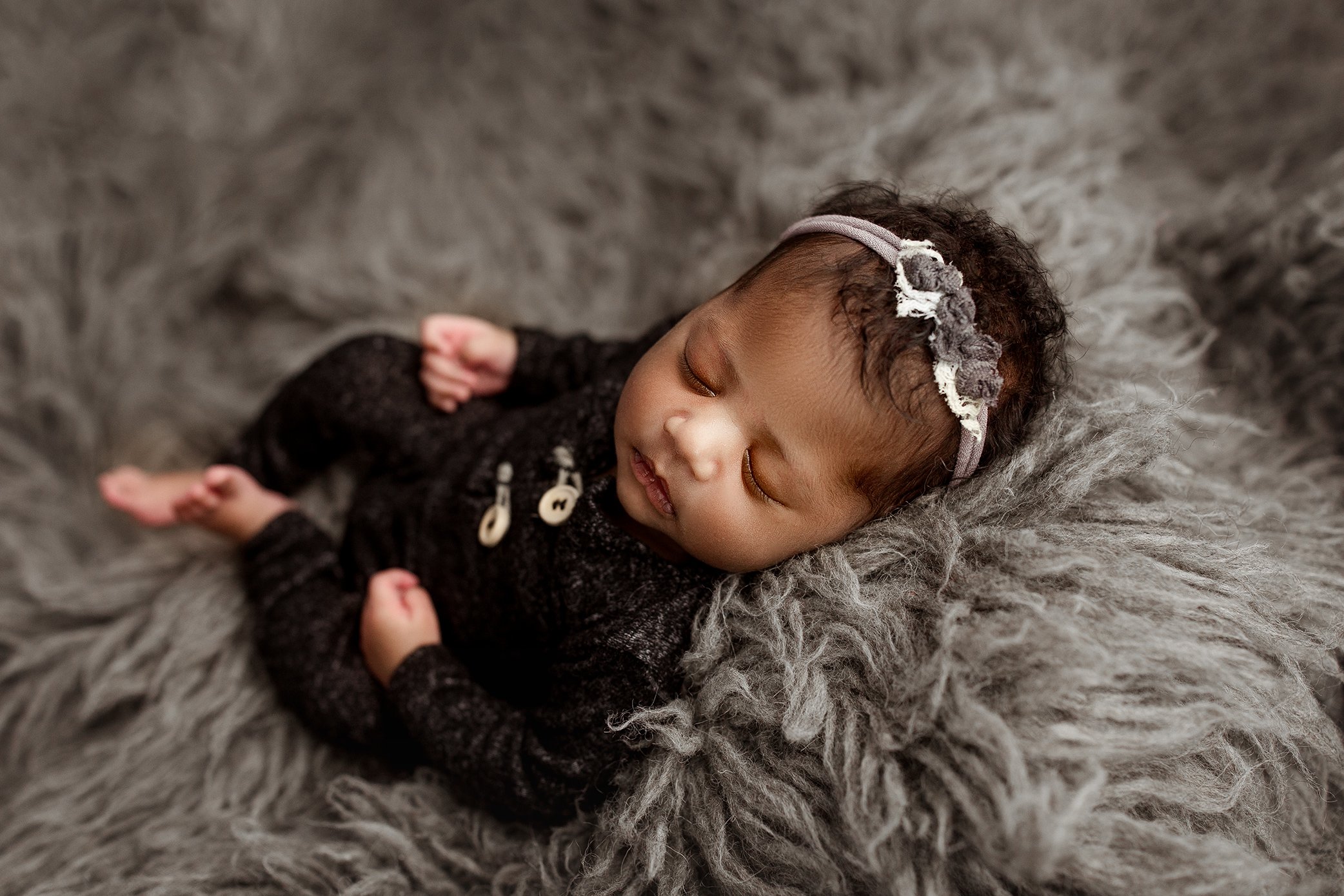 Newborn girl wearing charcoal romper