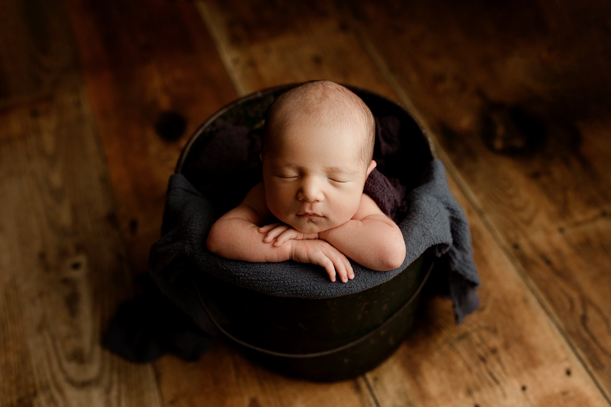 Newborn boy in bucket