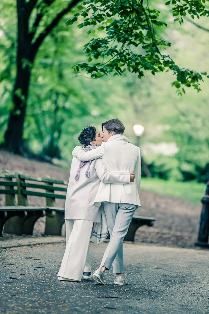 Couple kissing beneath the trees in Central Park during a New York fall wedding portrait session.