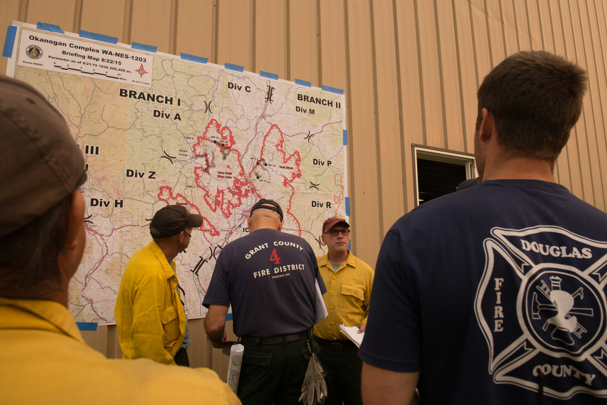  Firefighters are briefed on night shift assignments at the Incident Command Post Omak, Saturday August 22, 2015. Fire crews from around the United States, some from as far away as New Jersey, assemble here to receive their assignments before deployi