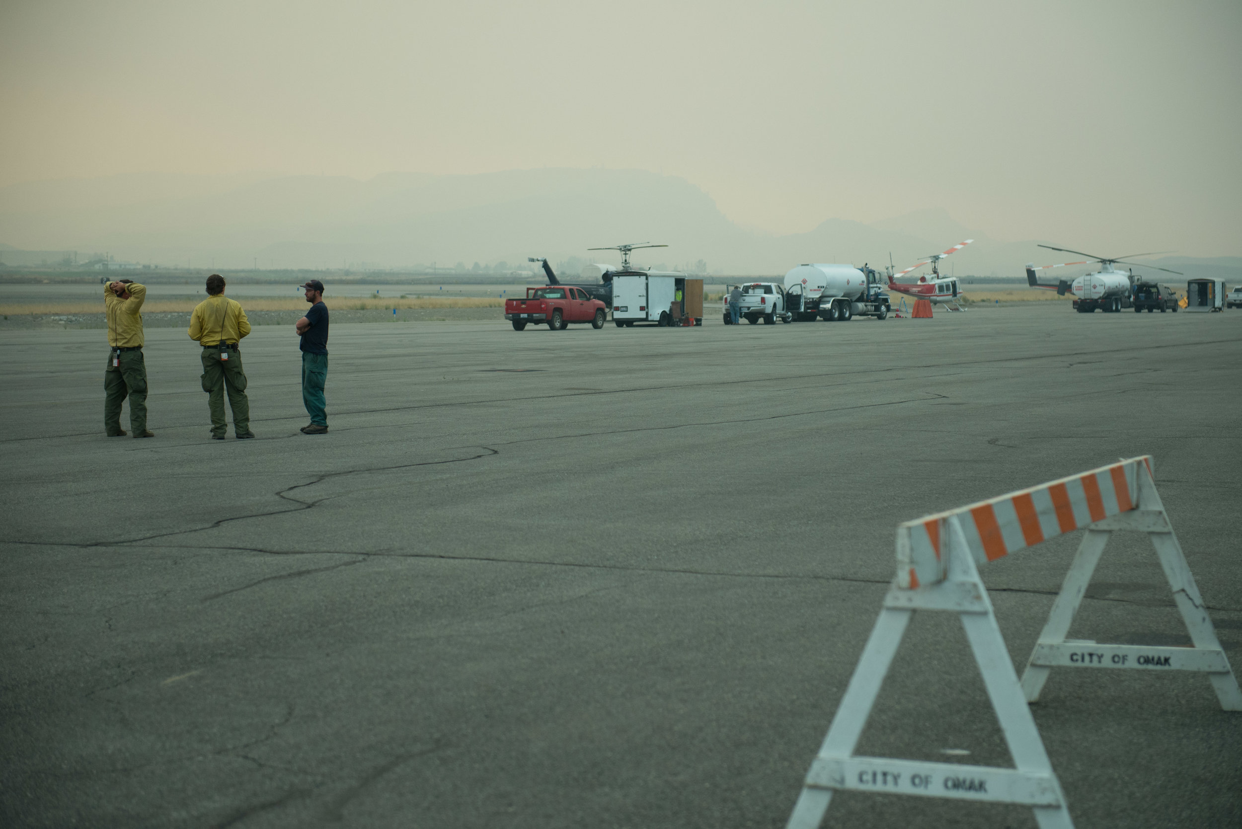  Fire fighters observe weather conditions at Omak Airport, Sunday August 23, 2015. An inverted weather pattern promoted smoky conditions in Okanogan County that slowed fire growth but also grounded fire-fighting aircraft. 