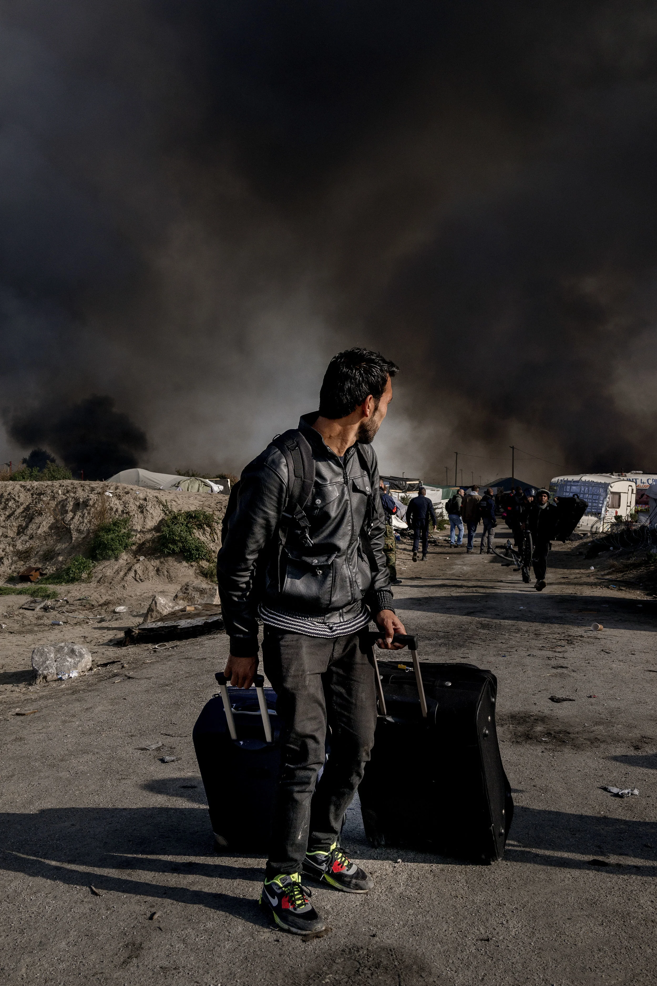 26th October 2016, The Jungle of Calais in France is in huge fire. Refugee leave the camp.