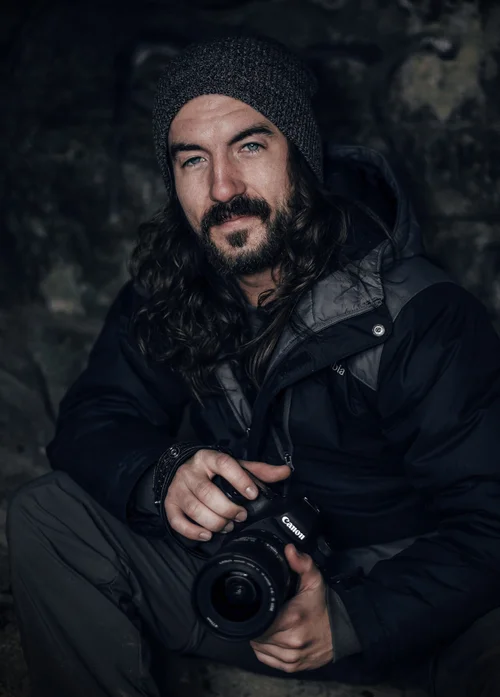 Adam Stagner holding his camera, shown in the complete portrait