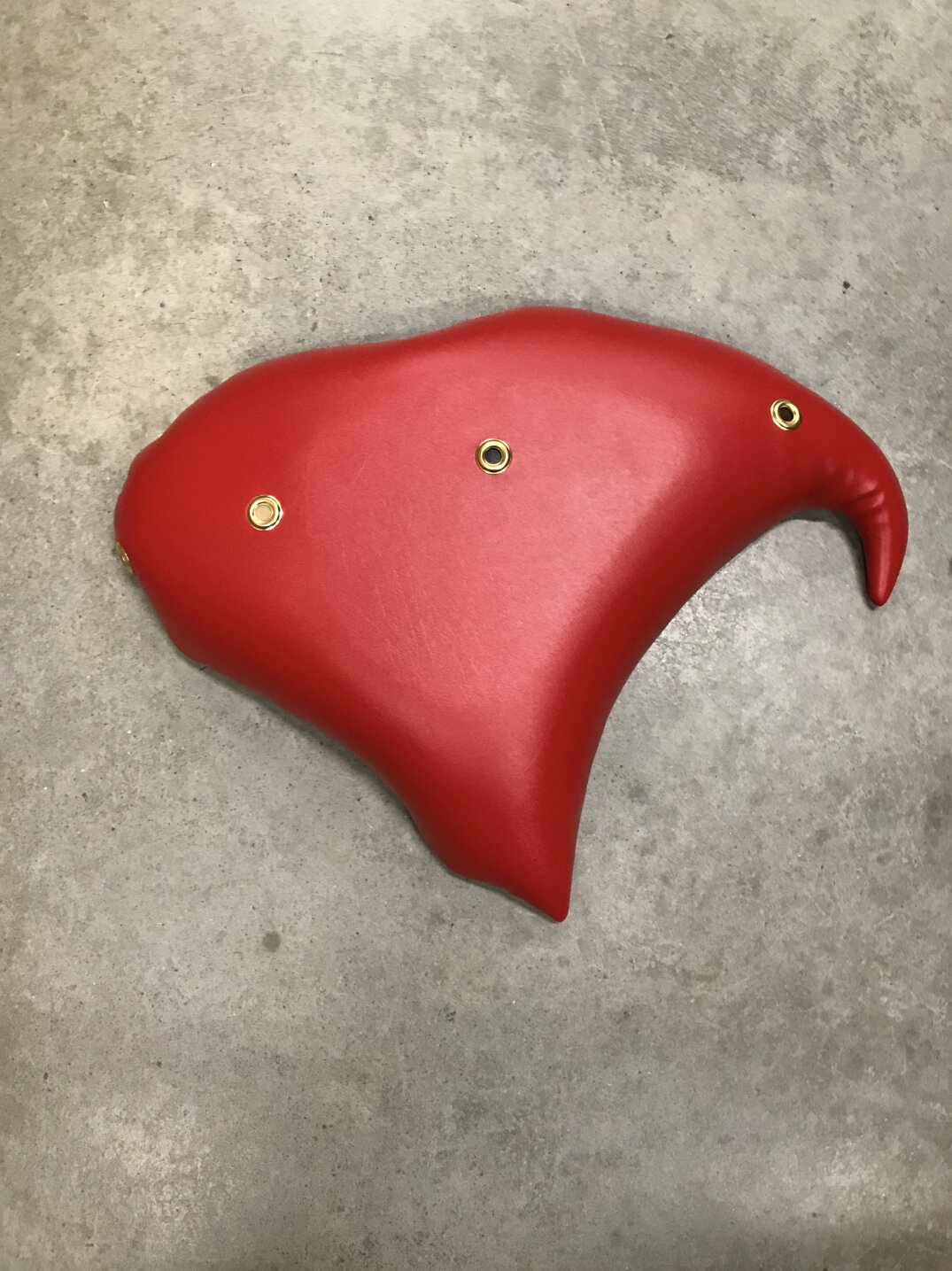 Baseera Khan, Seat 27 Red with Grommets, 2019. Pleather, gold grommets, 18 × 34 × 4 inches