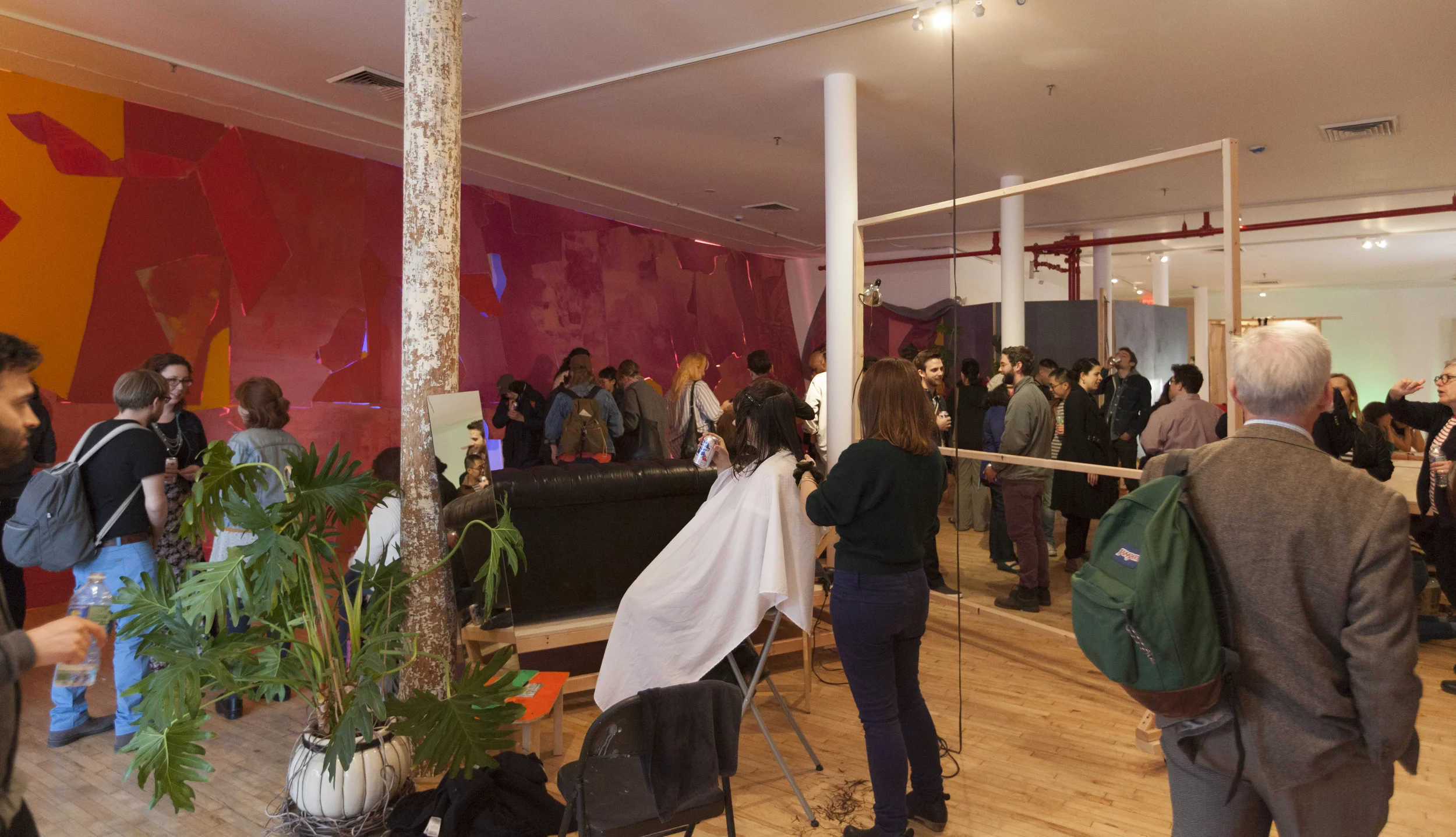 Foreground: Artist Brittany Mroczek cuts a clients hair at the opening of group show you know it when you feel it as part of Lisi Raskin’s Recuperative Tactics . Background: Flat Screen (Pink Wall) by Lisi Raskin, Art in General, April 19, 2014. Image credit: Steven Probert