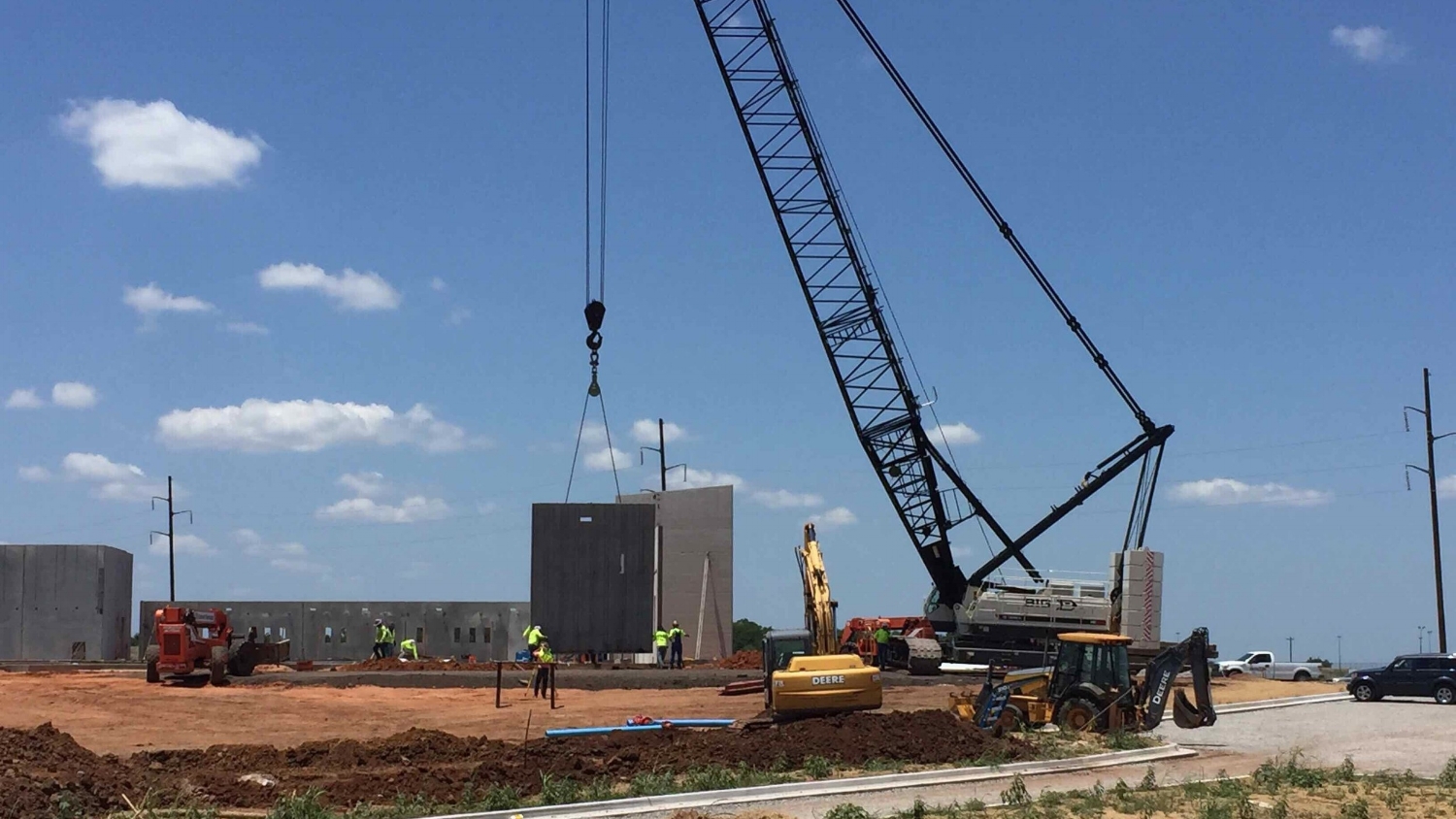 Workers install precast concrete wall panels at the Ardmore Readiness Center. The modular concrete panels decrease construction times and provide a high level of insulation to help the project meet LEED requirements.