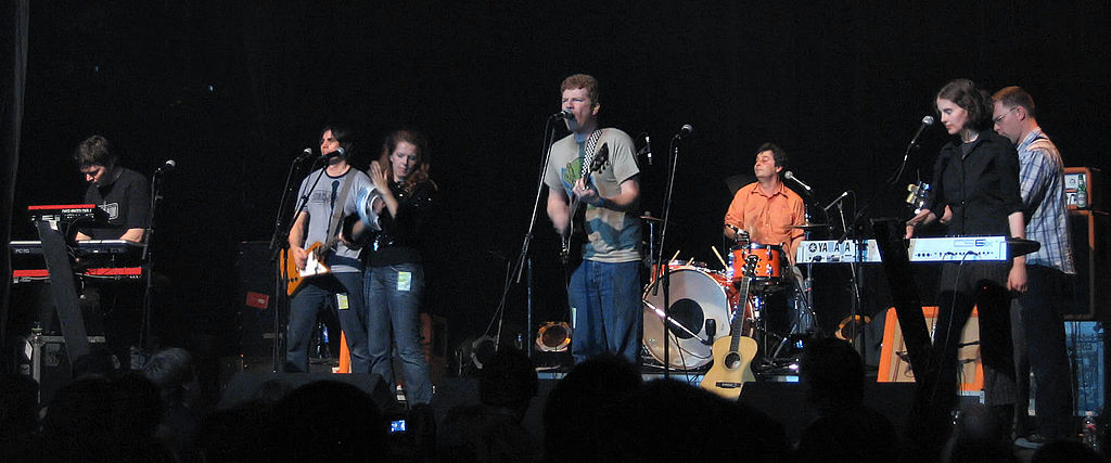 Left to right: Blaine Thurier , Todd Fancey , Neko Case , Carl Newman , Kurt Dahle , Kathryn Calder , John Collins. Image credit: Simon Law , via Wikimedia Commons.