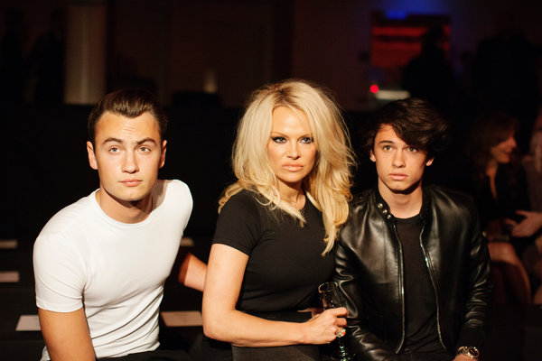 Ms. Anderson and her sons, Brandon Lee, left, and Dylan Lee, right, at the Saint Laurent show in Los Angeles in February. Emily Berl for The New York Times