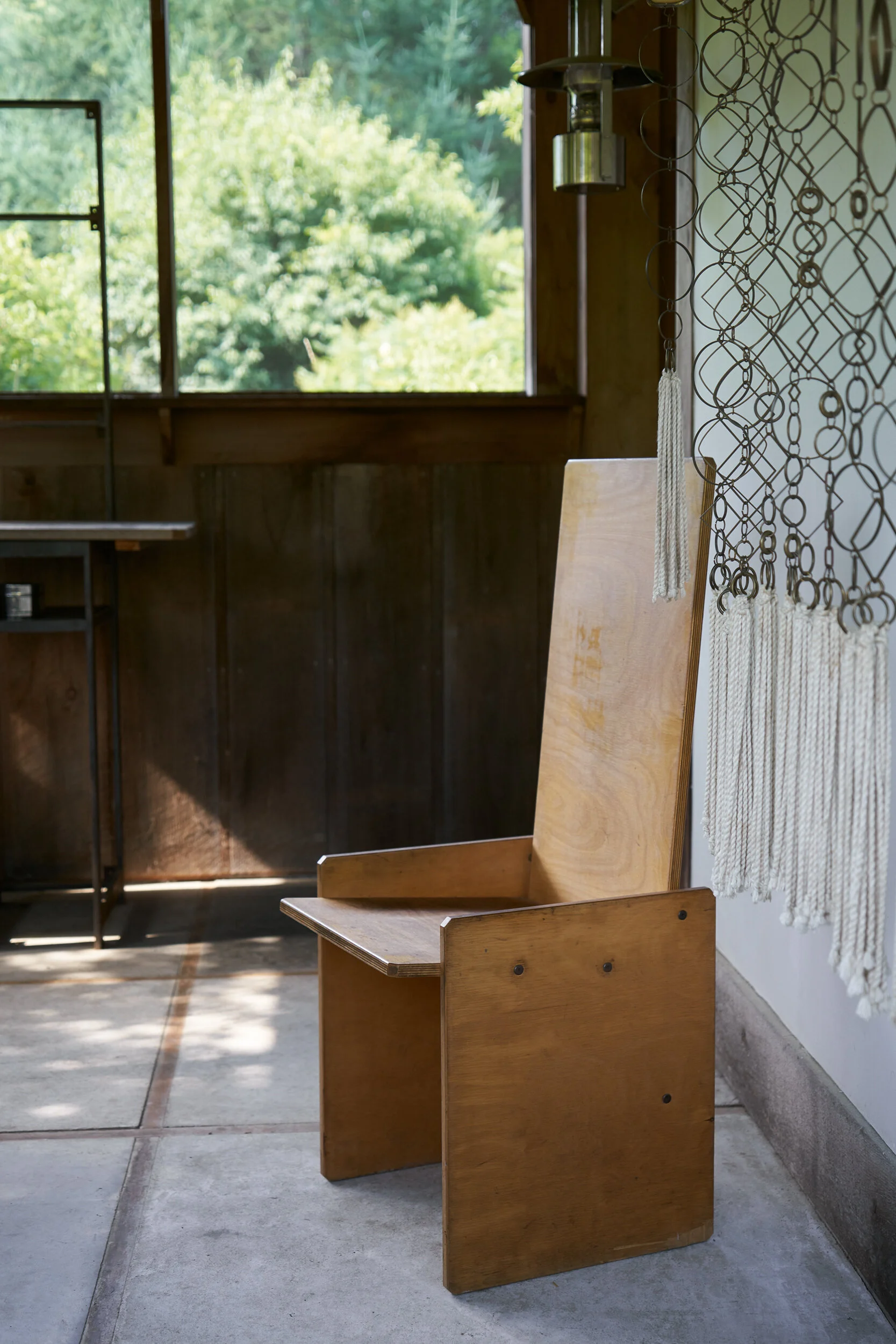 Plywood chair , 1975, and a tasseled brass partition (work in progress)