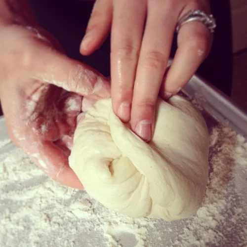Flour your work surface and turn the dough out. Pretend it has 4 sides and fold each side towards the center.