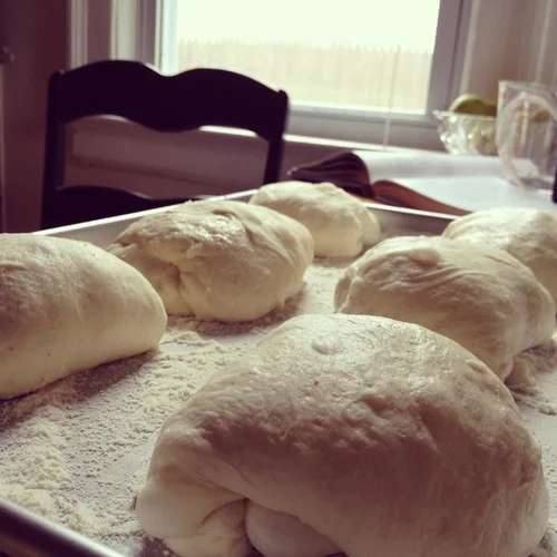 Then come back and flour your hands, gathering each round of dough into a tight ball. Generously dust a baking sheet with flour and place them on there. Cover the baking sheet with a dishtowel and leave them alone for an entire hour.