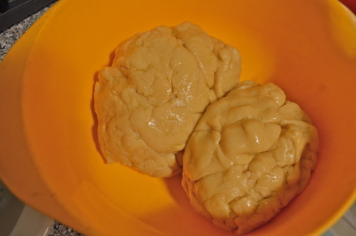 (FYI, you see two balls because we made two batches.) Put the ball into an oiled bowl, turn to coat for a nice shine, and cover with plastic wrap.