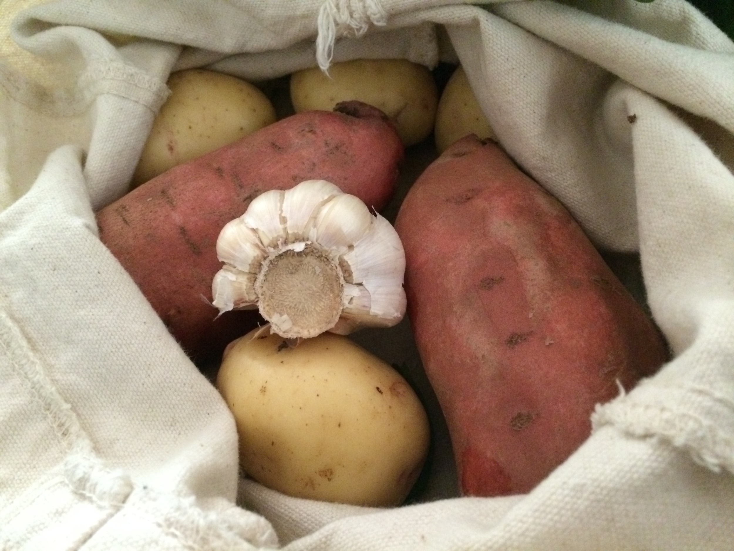  Come hither and peep my satchel. In it, you&#39;ll see 2 large sweet potatoes, 4 small white potatoes, and some garlic. 