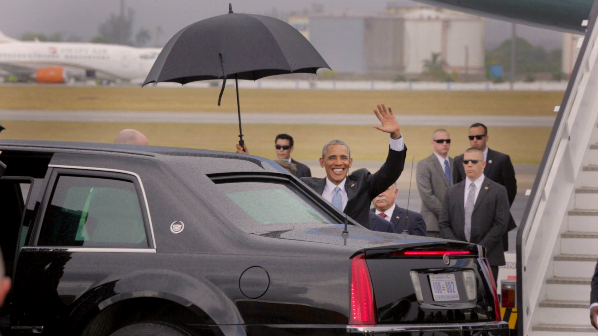  CUBA- President Barack Obama, surrounded by security, greeted the reporters as he gets into a car. This happened immediately after getting off the presidential plane.

El presidente Barack Obama, rodeado de seguridad, saluda a los periodistas mientr