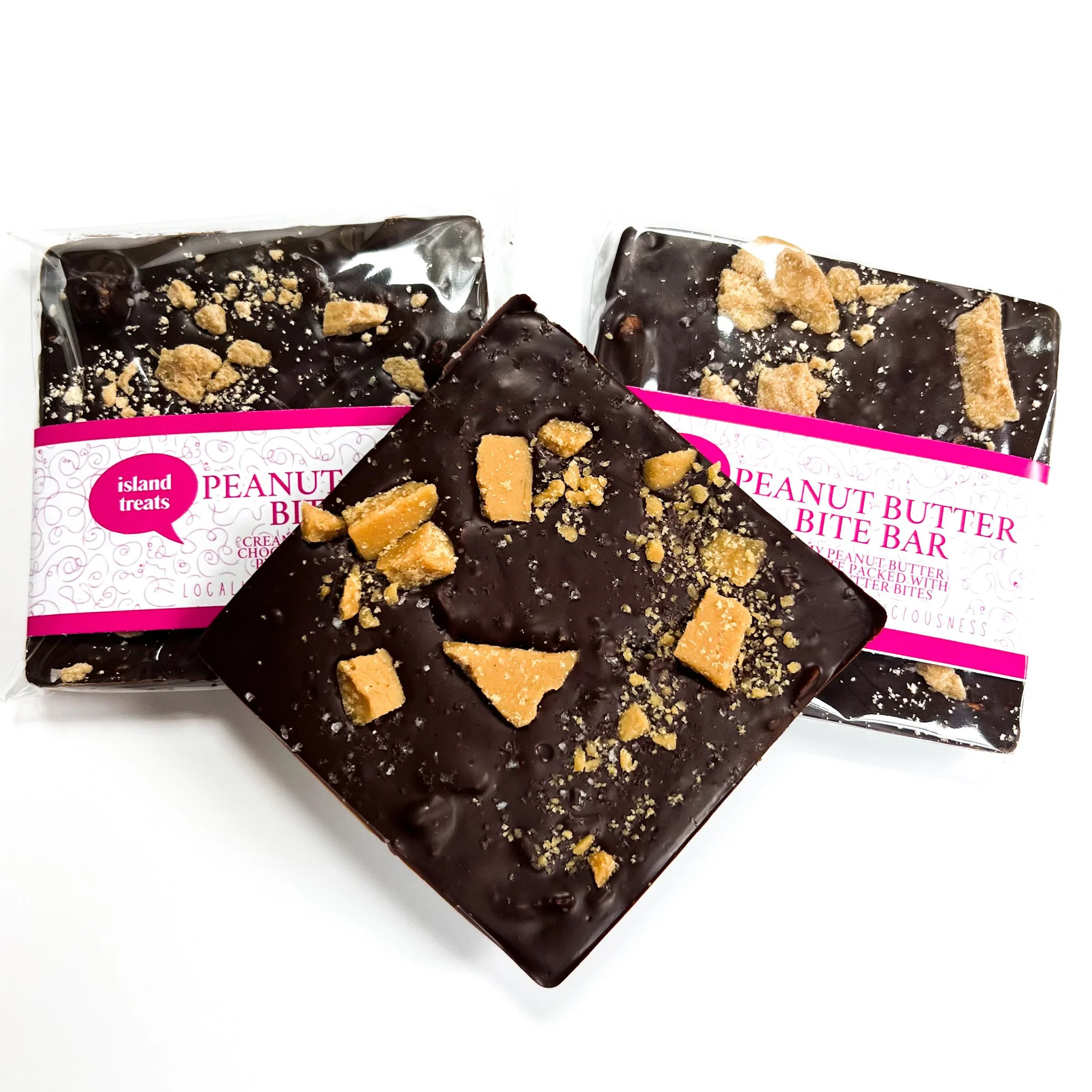 Unwrapped chocolate-covered peanut butter ice cream bars topped with crushed cookies on white background.