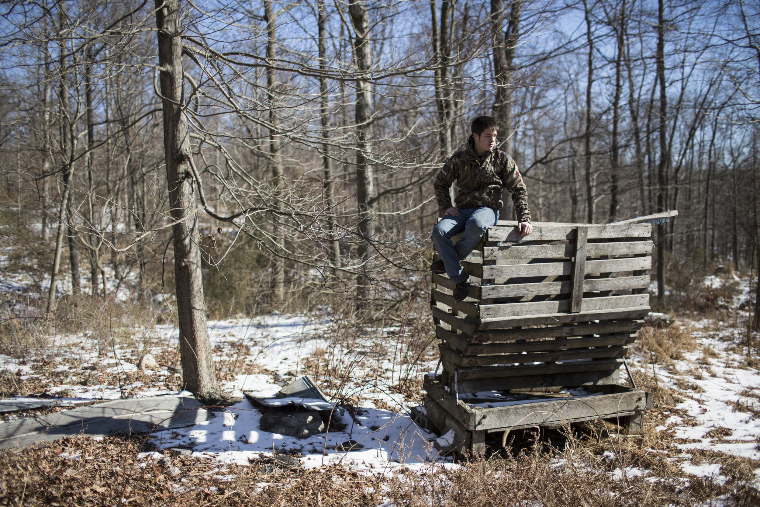 Hunter sits atop an old feeder during a winter work party at the Heartwood Outdoors hunting camp near Indian Springs, Maryland. 