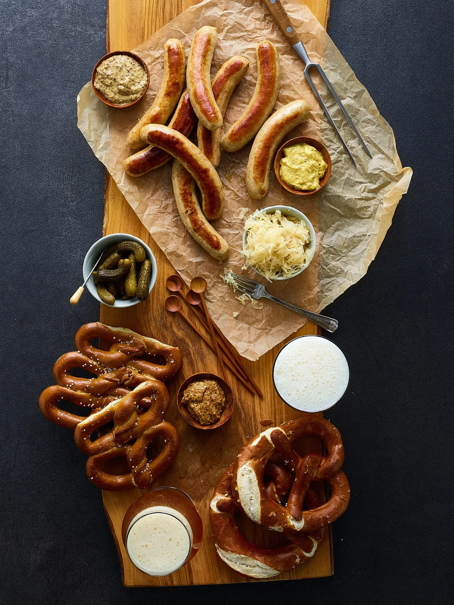 Oktoberfest feast sausages pretzels dark wood overhead food advertising photography by Dhanraj Emanuel, studio food photographer Greensboro NC
