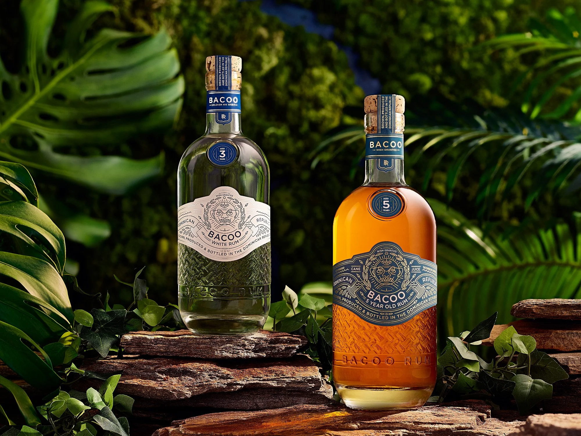 Beverage advertising photography by Dhanraj Emanuel — Bacoo White and Aged Rum bottles styled with tropical foliage on rustic wood. Commercial spirits photographer for beverage brands and advertising agencies, available nationwide..