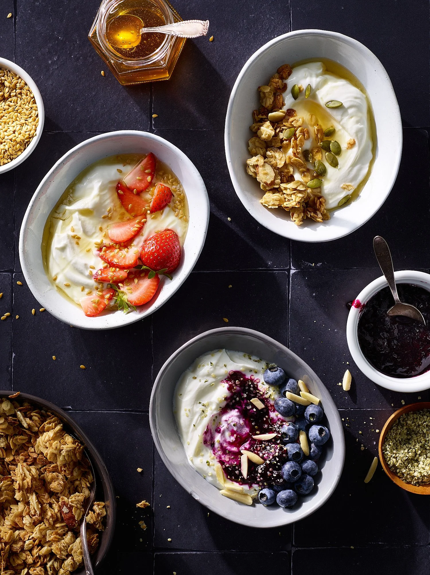 Yogurt bowls overhead dark surface granola berries CPG food advertising photography by Dhanraj Emanuel, studio food photographer Greensboro NC