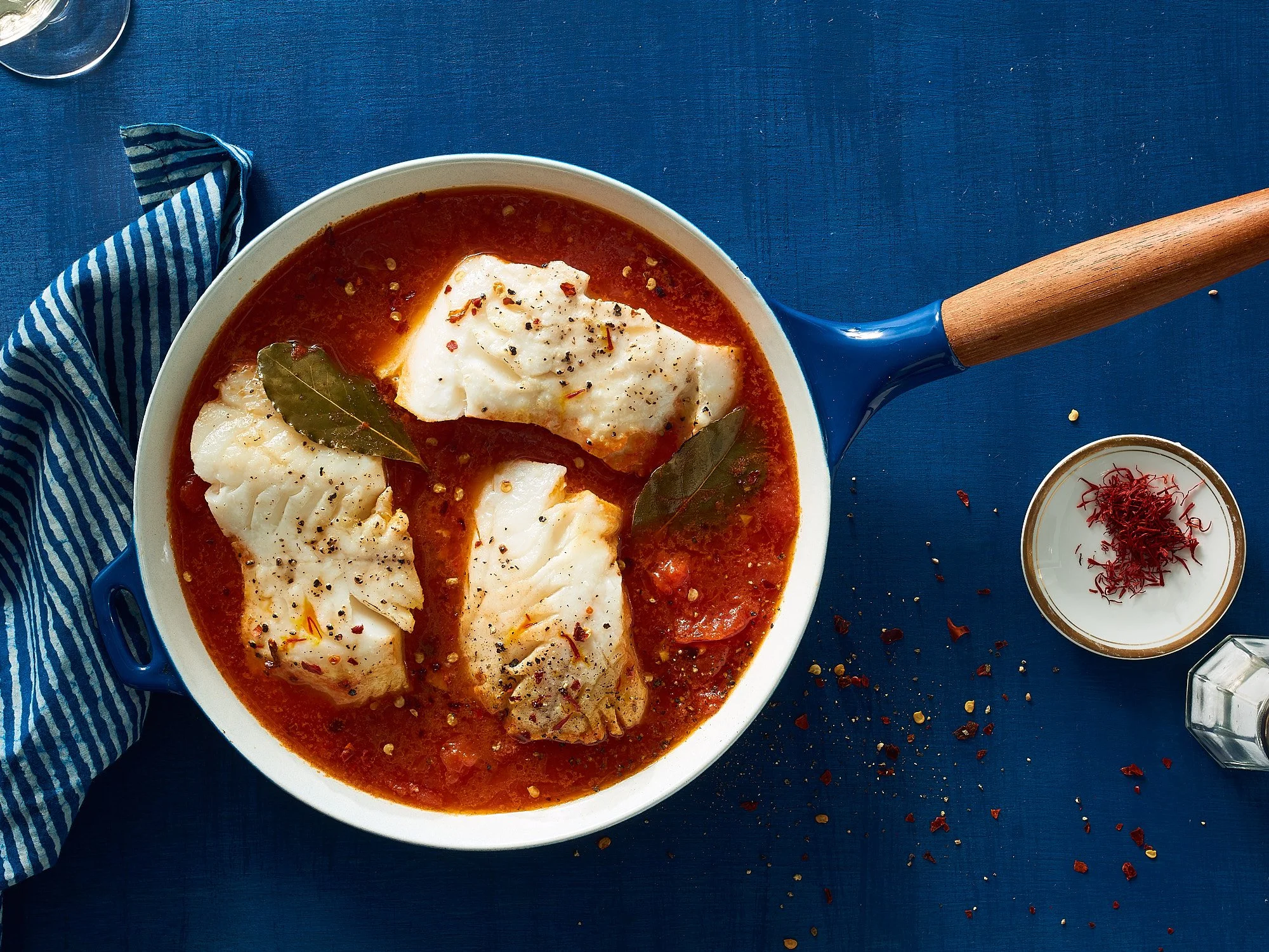 Commercial food photography by Dhanraj Emanuel — cod in tomato sauce with saffron on deep blue surface, shot for The Fresh Market. Food and beverage advertising photographer based in Greensboro NC, working nationally.