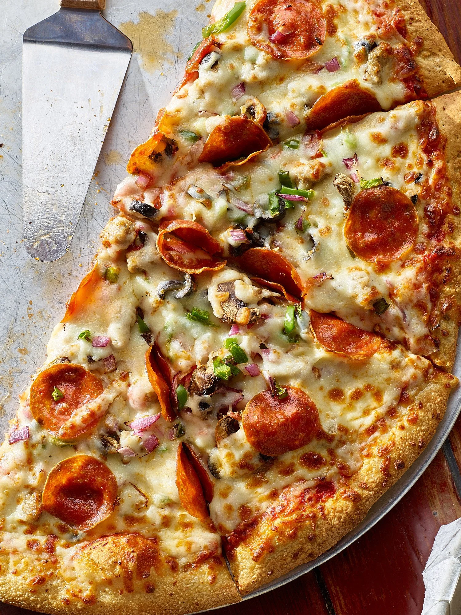 Commercial food photography by Dhanraj Emanuel — close-up of pepperoni and vegetable pizza with melted cheese on golden crust, shot for restaurant and CPG clients. Food advertising photographer available nationwide.