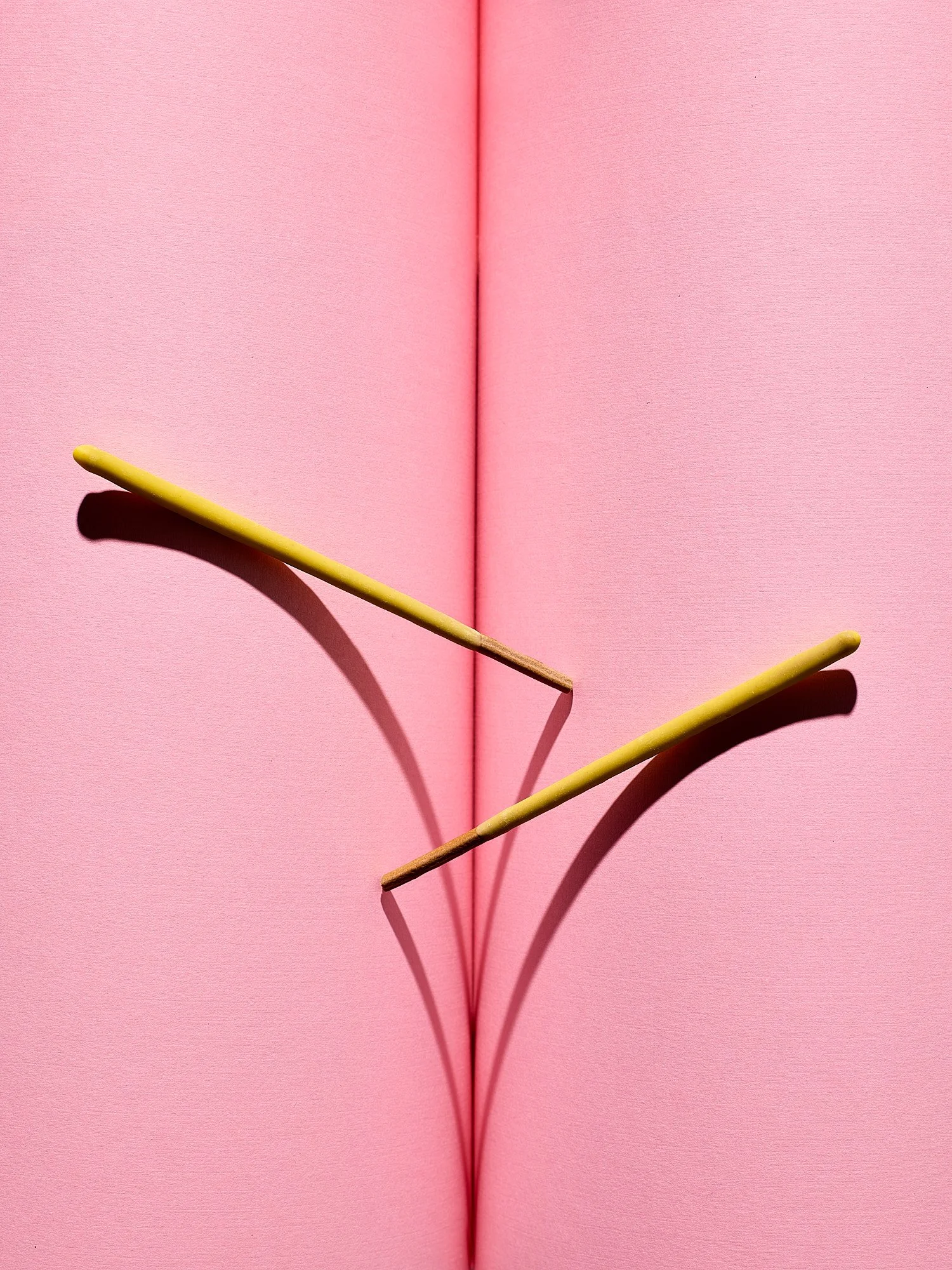 Pocky chocolate sticks pink surface graphic conceptual confectionery advertising photography by Dhanraj Emanuel, food photographer Greensboro NC