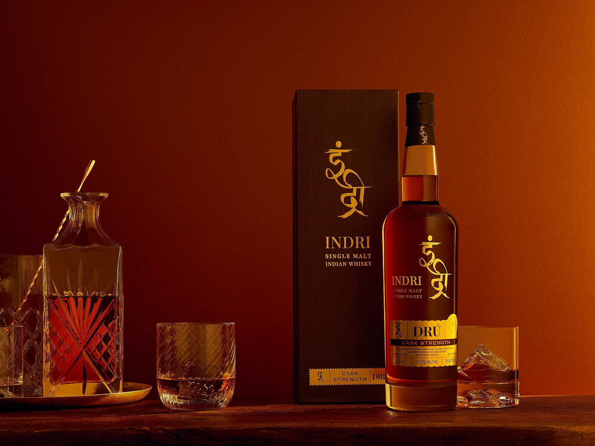 Indri single malt Indian whiskey Piccadily Distilleries bottle and glasses warm amber advertising photography by Dhanraj Emanuel, spirits photographer Greensboro NC