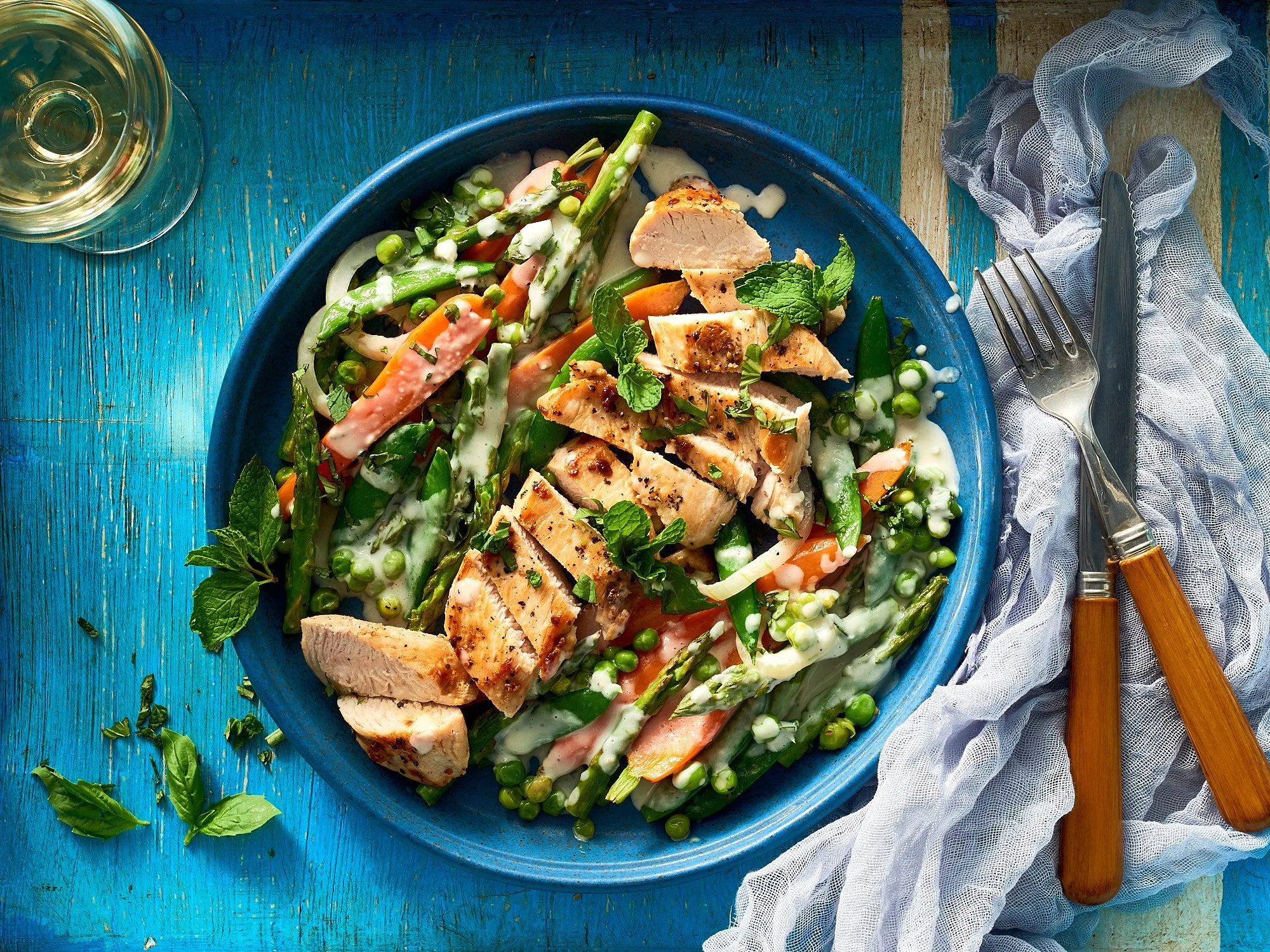 Commercial food photography by Dhanraj Emanuel — grilled chicken salad with creamy dressing on blue ceramic, styled for advertising and editorial clients. Food and beverage photographer available nationwide.
