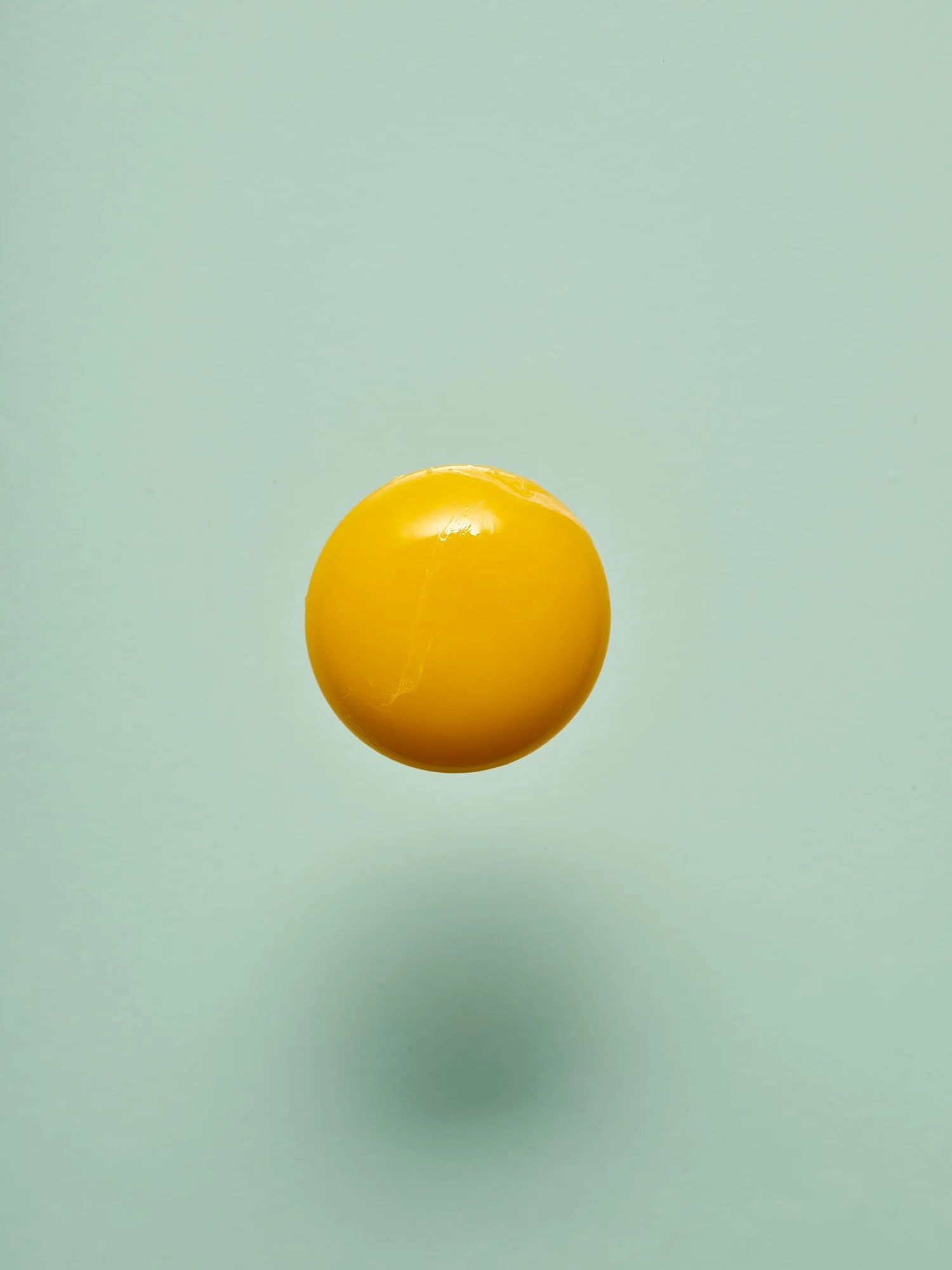 Egg yolk floating Itten's color contrasts warm cold fine art conceptual food photography by Dhanraj Emanuel, advertising photographer Greensboro NC