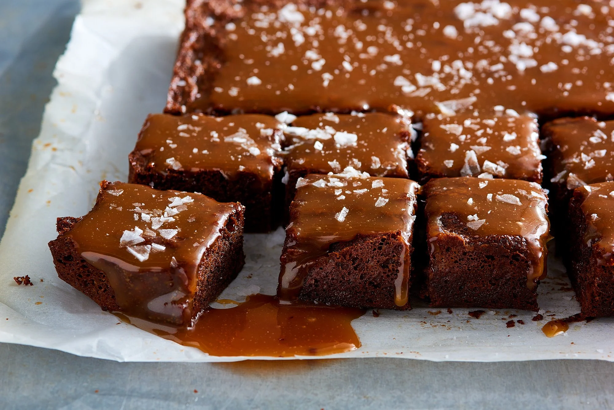 Food advertising photography by Dhanraj Emanuel — chocolate caramel brownies with flaky sea salt on parchment, shot for The Fresh Market. Commercial food photographer for CPG and grocery brands, available nationwide..