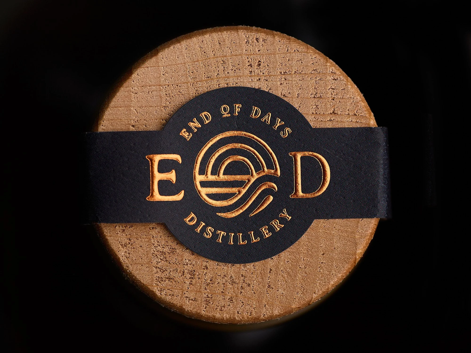 Wooden barrel with a black label reading 'End of Days Distillery' in gold lettering