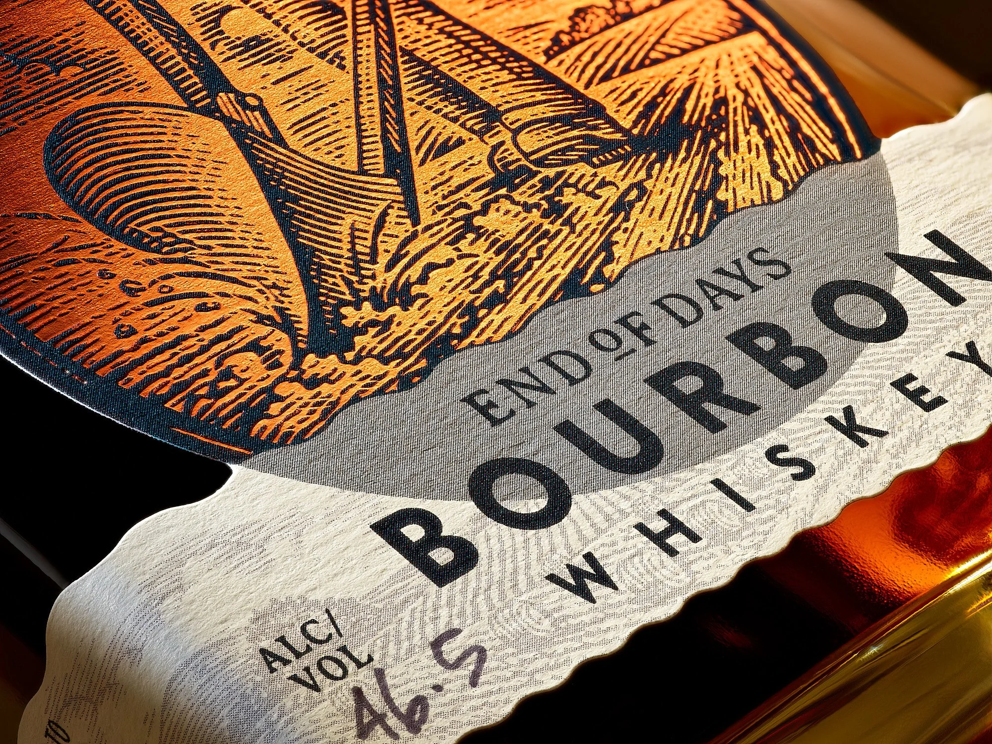 Spirits advertising photography by Dhanraj Emanuel — close-up of End of Days Bourbon Whiskey bottle label with illustrated woodworker detail. Commercial beverage photographer for craft spirits brands and advertising agencies, available nationwide.