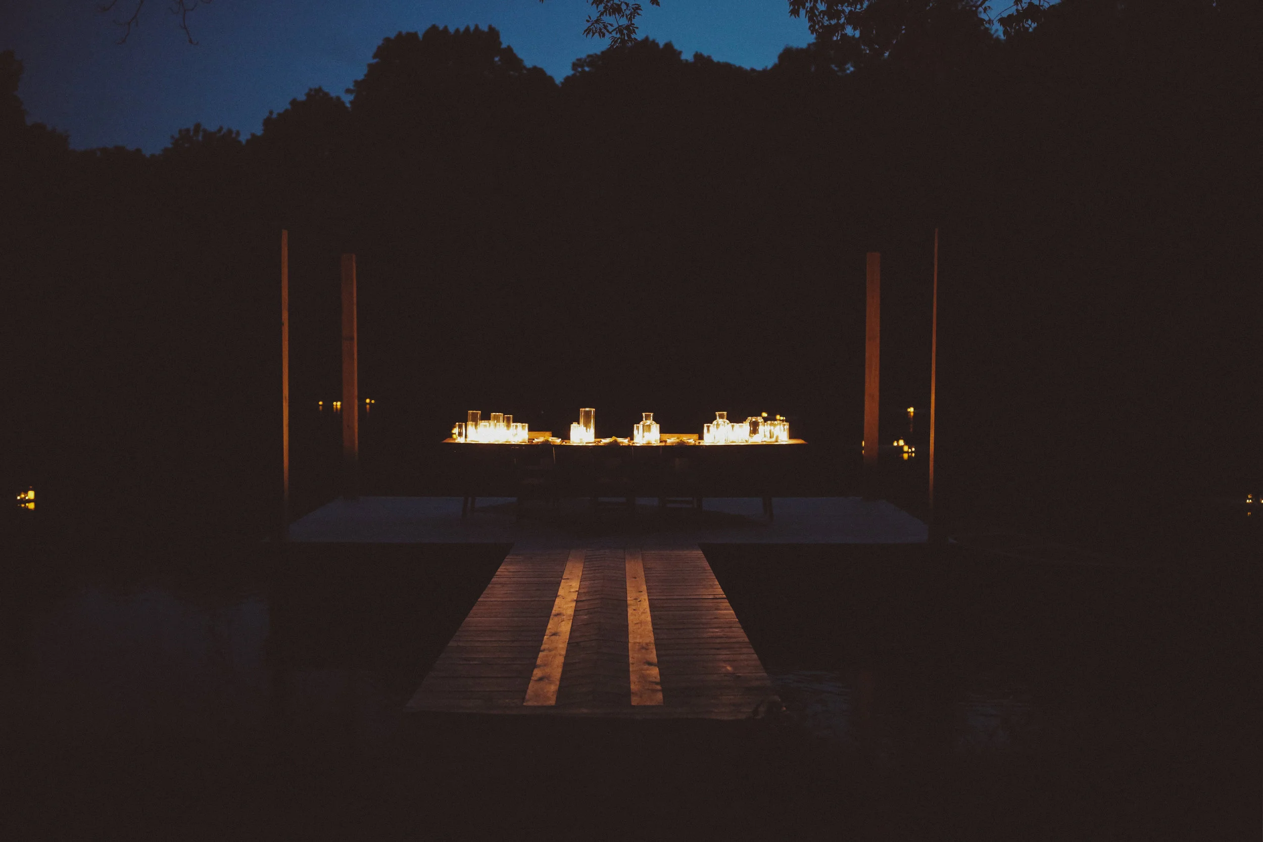 Dinner on a dock surrounded by floating, candle covered turkish rugs.