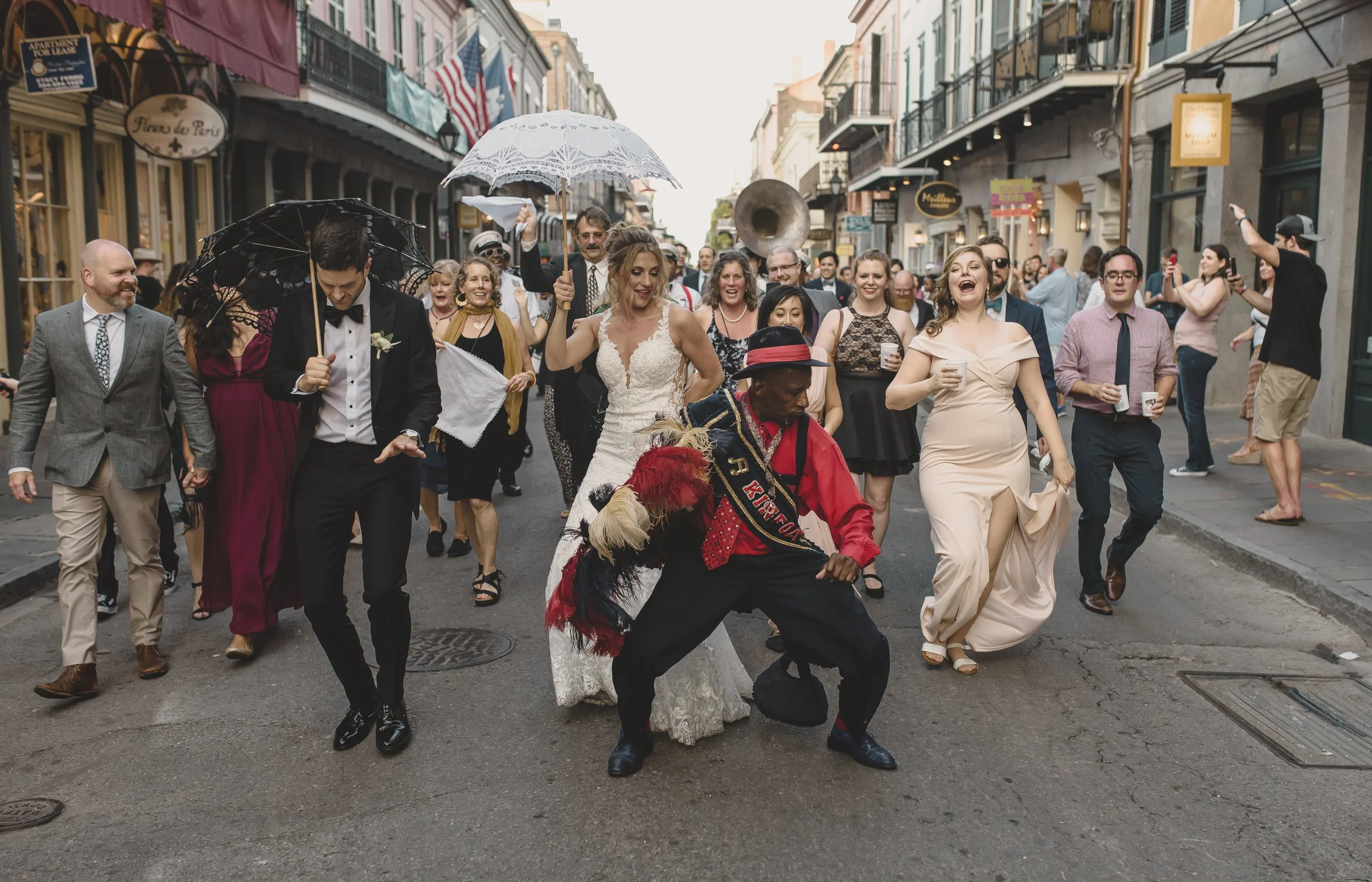 Newlyweds and their guests celebrate during a daytime second line in the French Quarter.