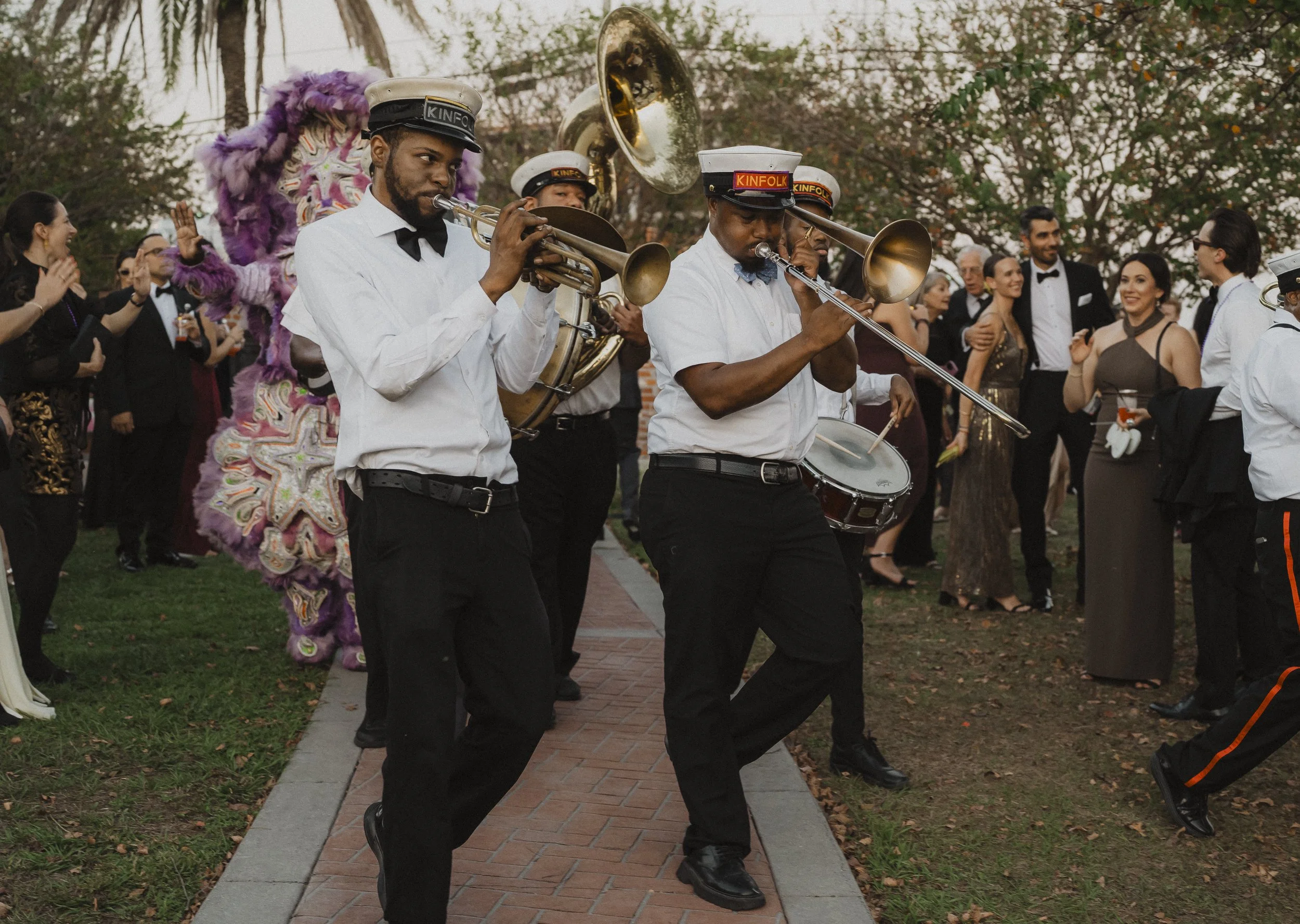 Brass band leading wedding guests during a Race + Religious second line