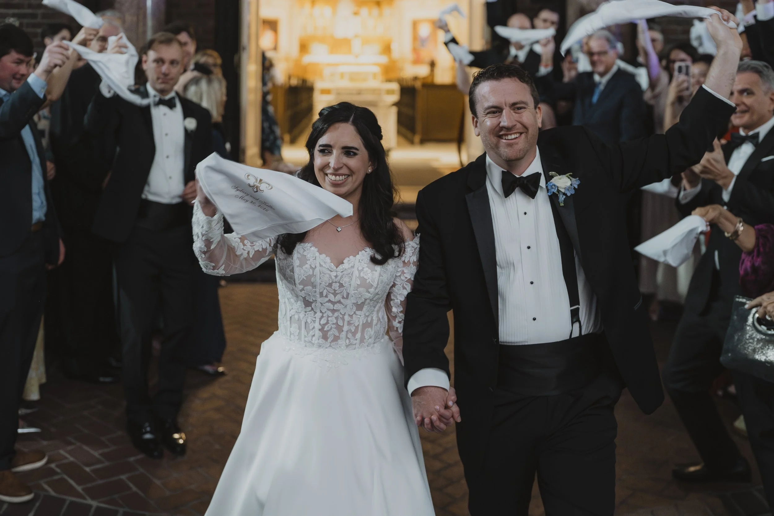 Newlyweds lead a second line as guests wave handkerchiefs at a New Orleans wedding.