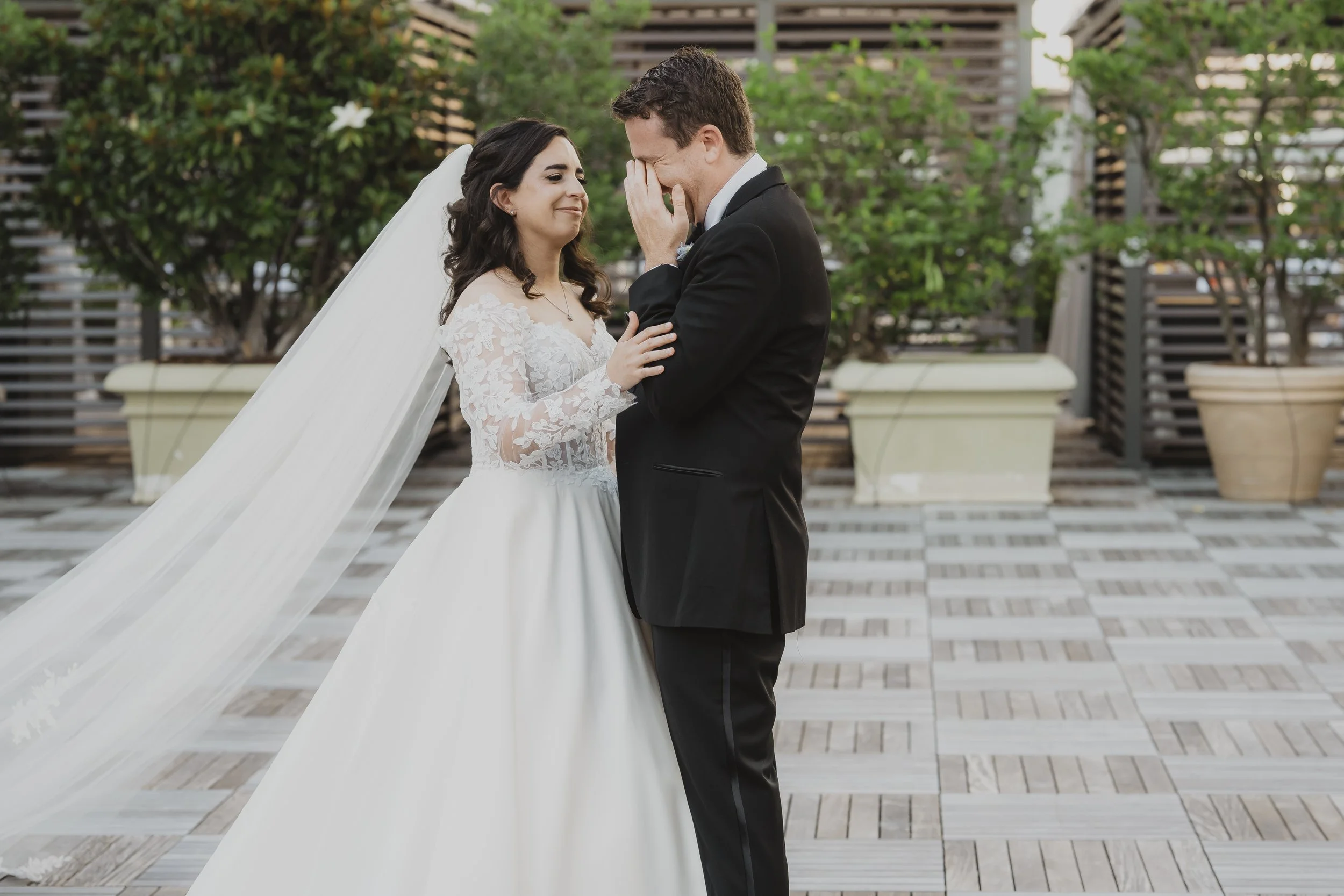 Newlyweds stand together for a relaxed portrait in a New Orleans courtyard.