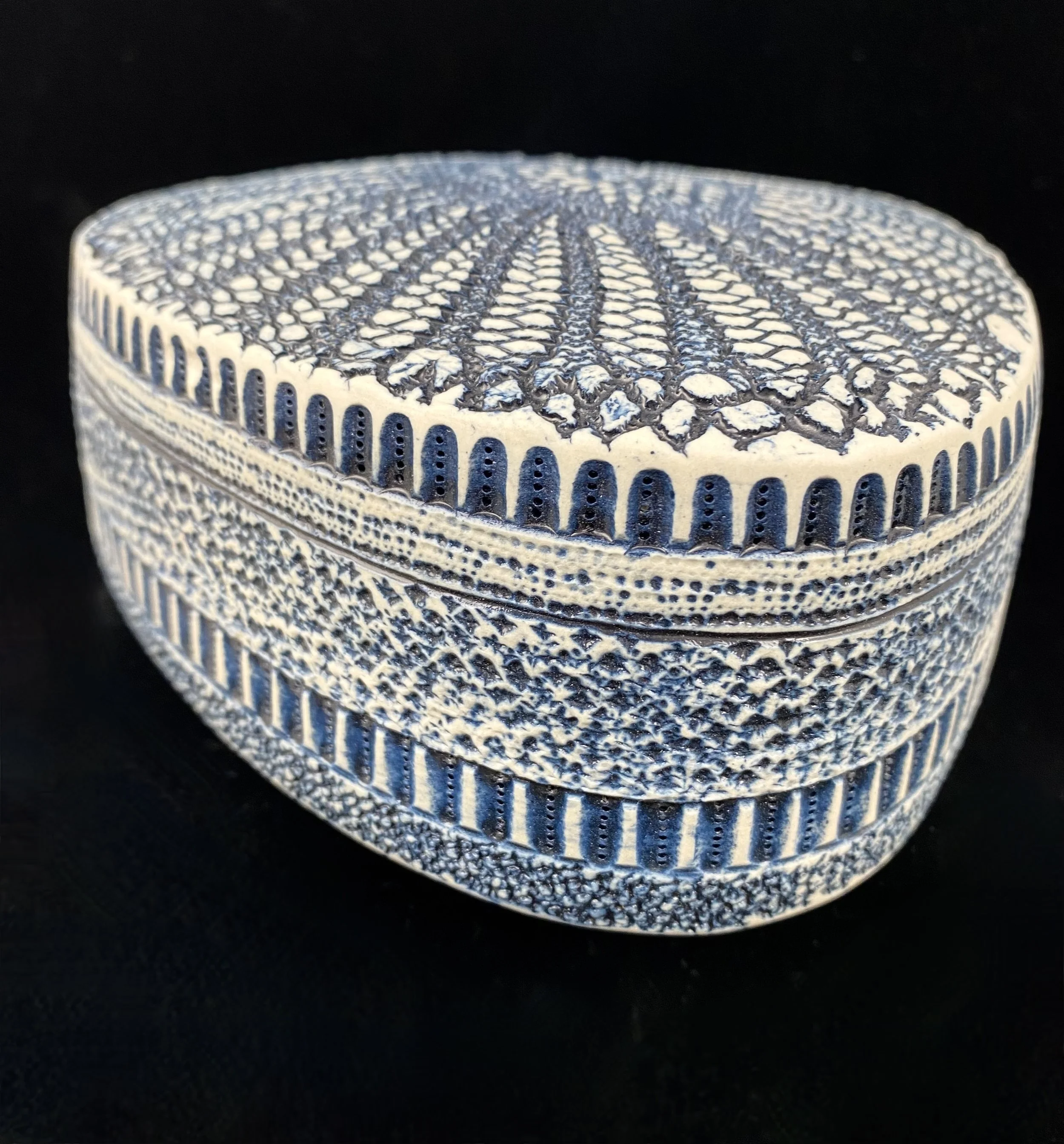 Triangular diatom sculpture with cobalt oxide wash