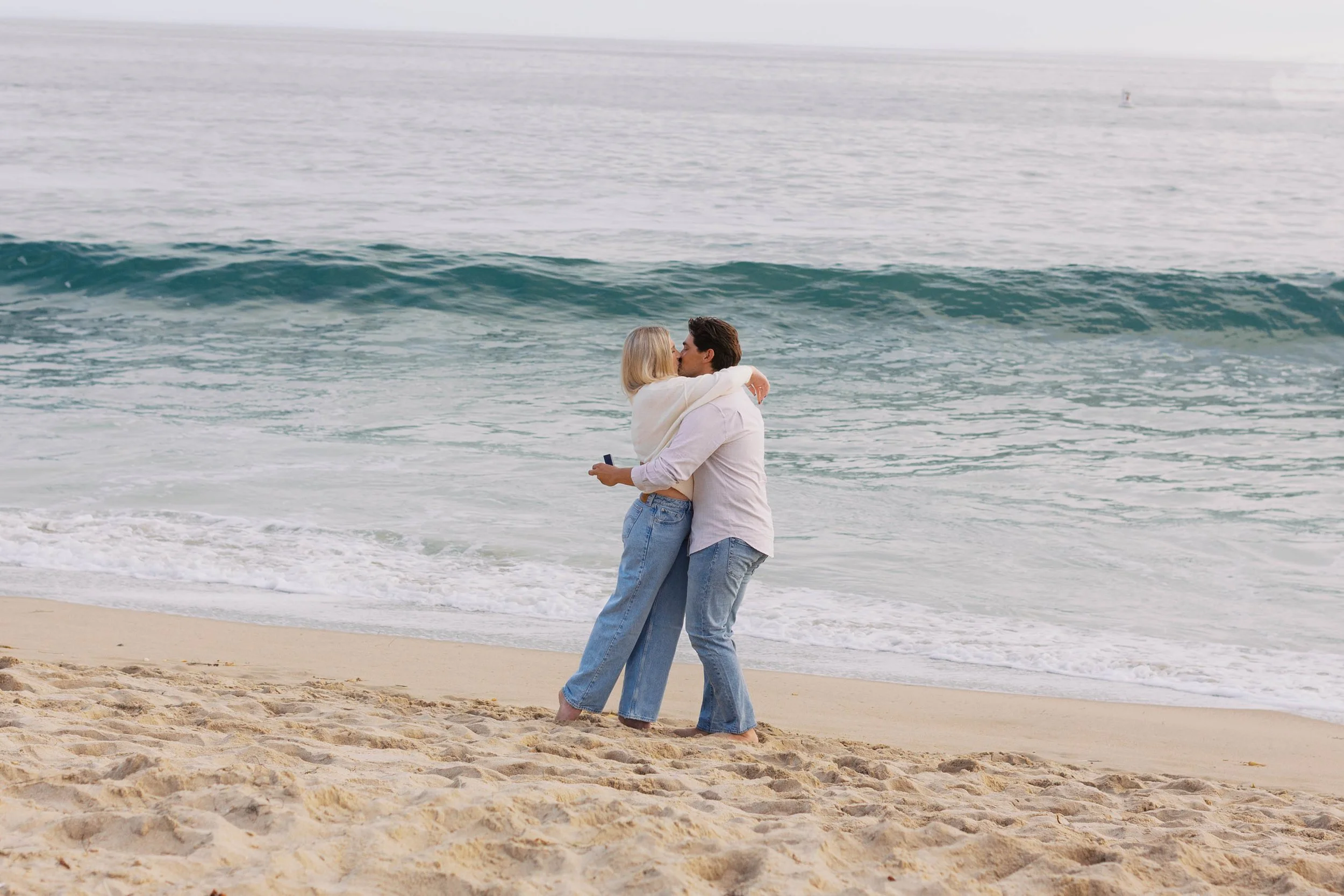 Newly engaged couple kissing after their Emerald Bay proposal in Laguna Beach, photographed by Alissa Noelle Photography.