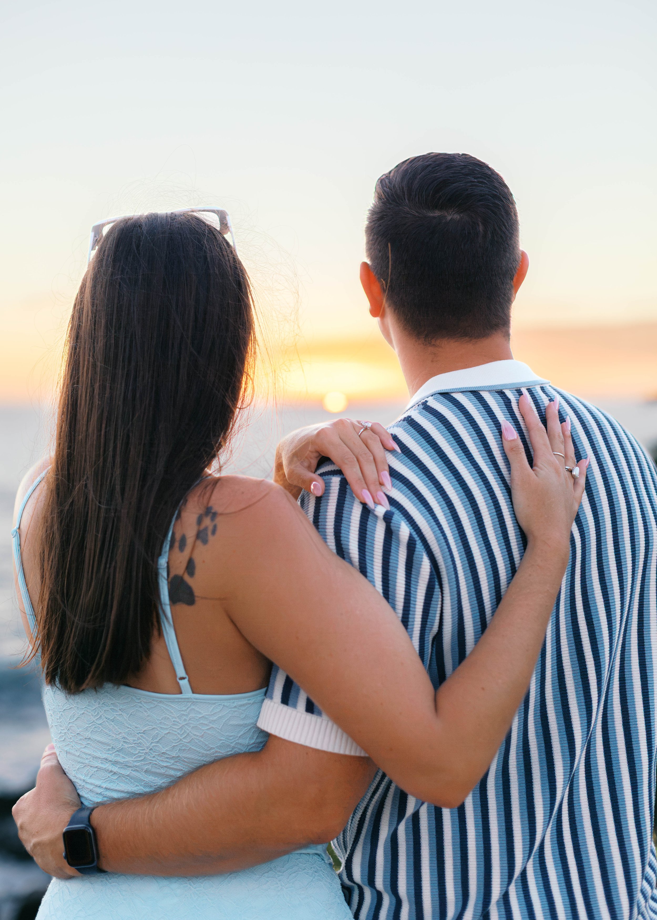 Newly engaged couple watching the sunset over the Pacific Ocean after their Treasure Island proposal in Laguna Beach.