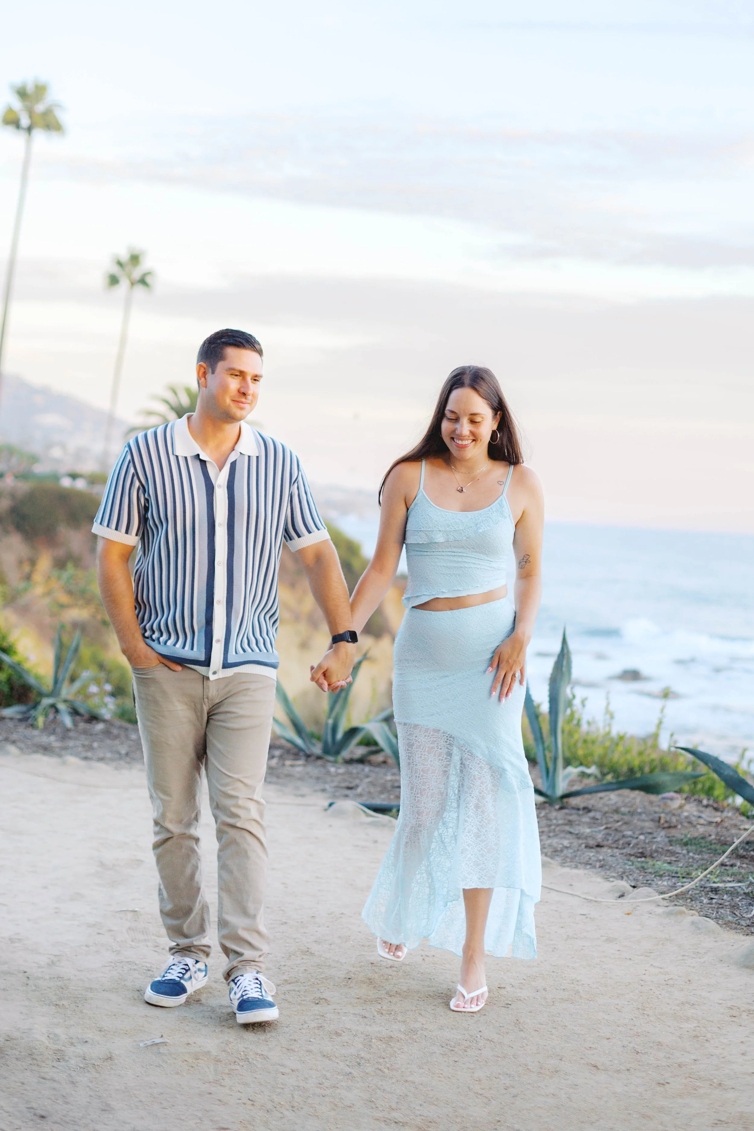 Newly engaged couple walking along the coastal path after their Treasure Island Beach proposal in Laguna Beach.