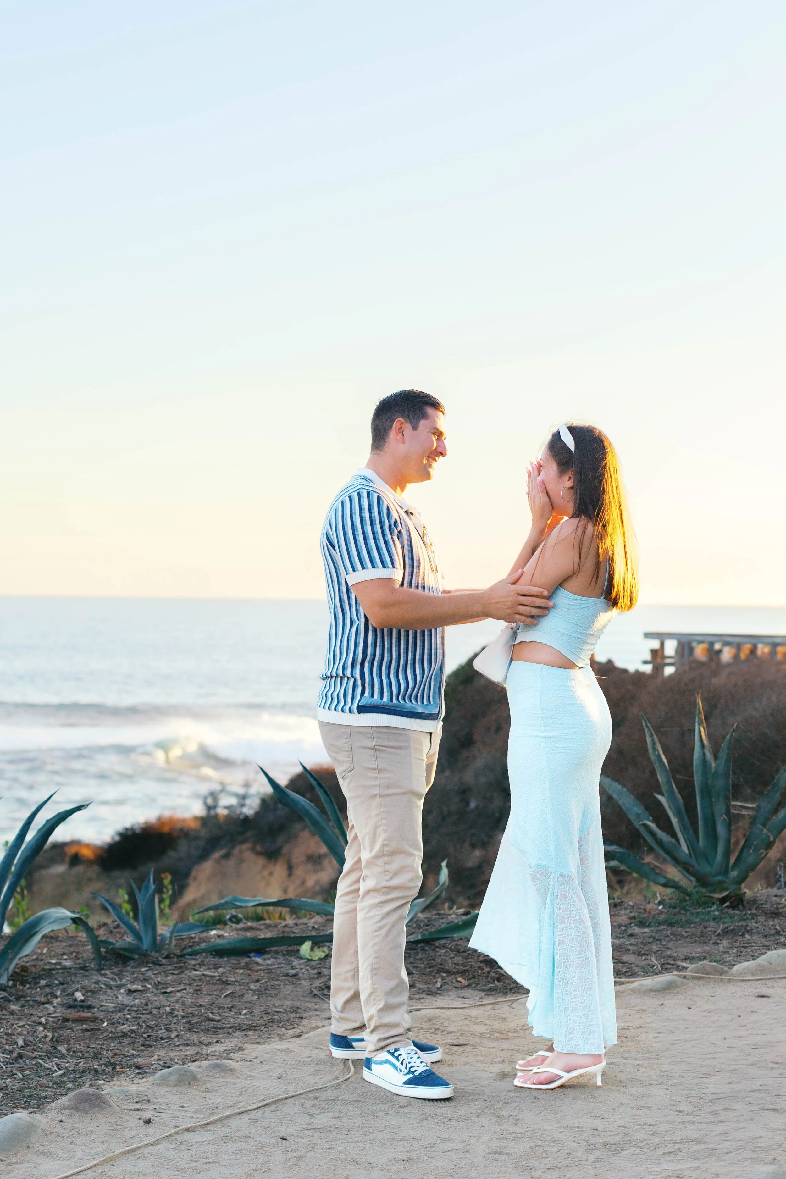 Newly engaged couple celebrating after a surprise proposal overlooking Treasure Island Beach in Laguna Beach.