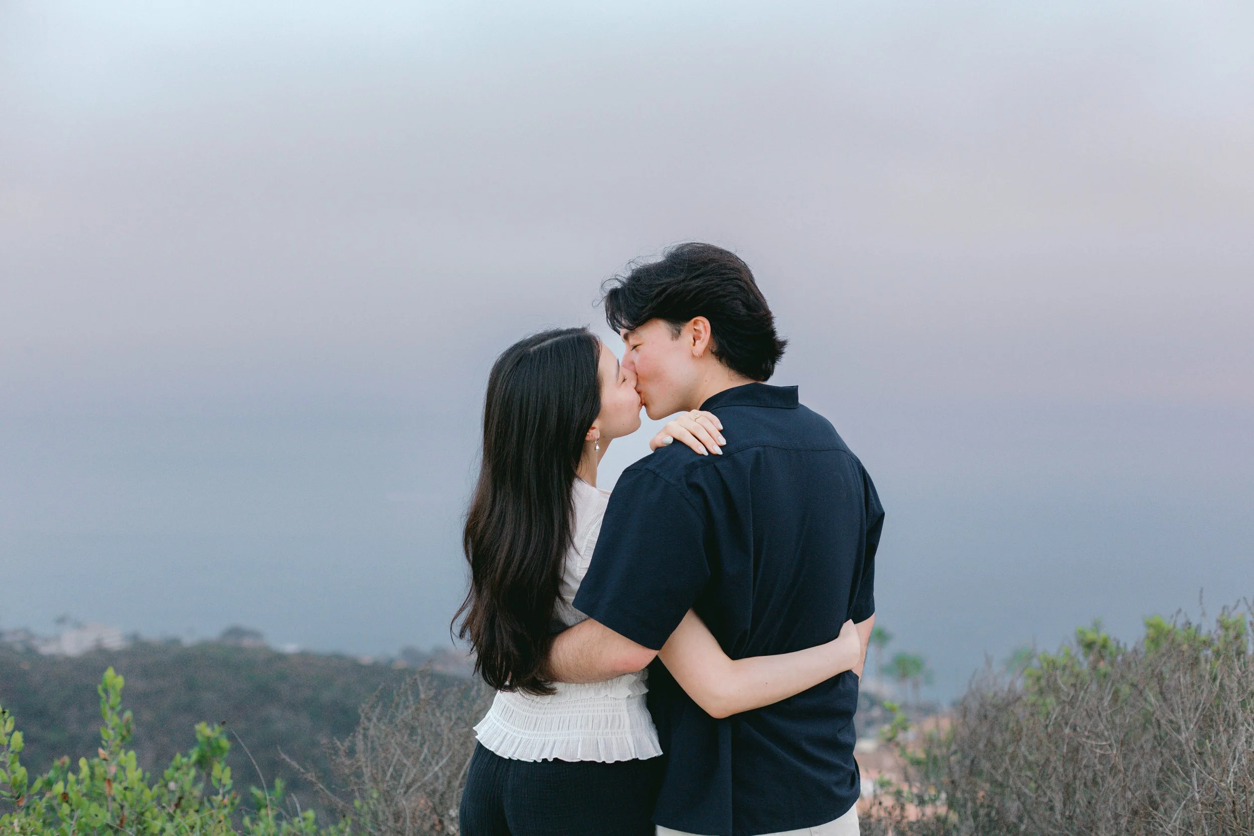 Romantic sunset kiss overlooking the hills at Seaview Park near Laguna Beach.