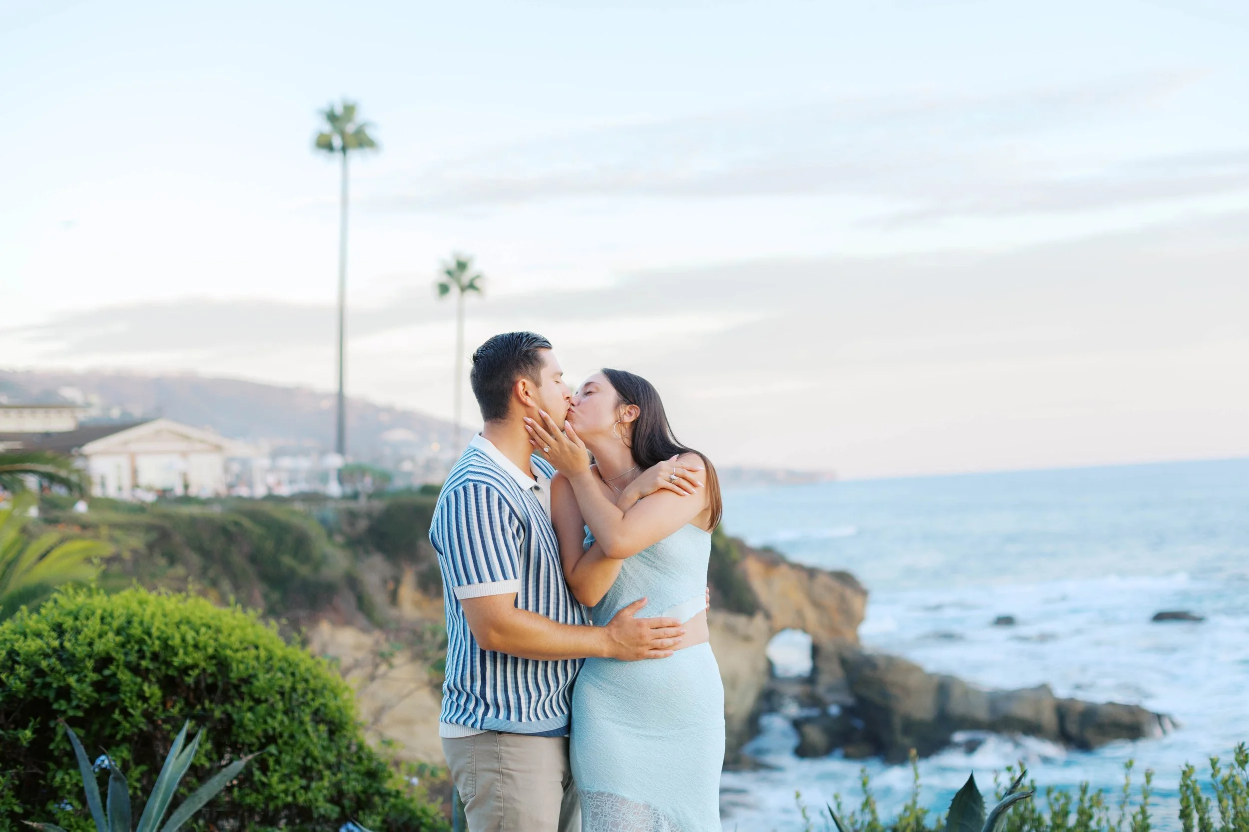 Romantic engagement photo overlooking the Laguna Beach coastline after a surprise proposal at Treasure Island.