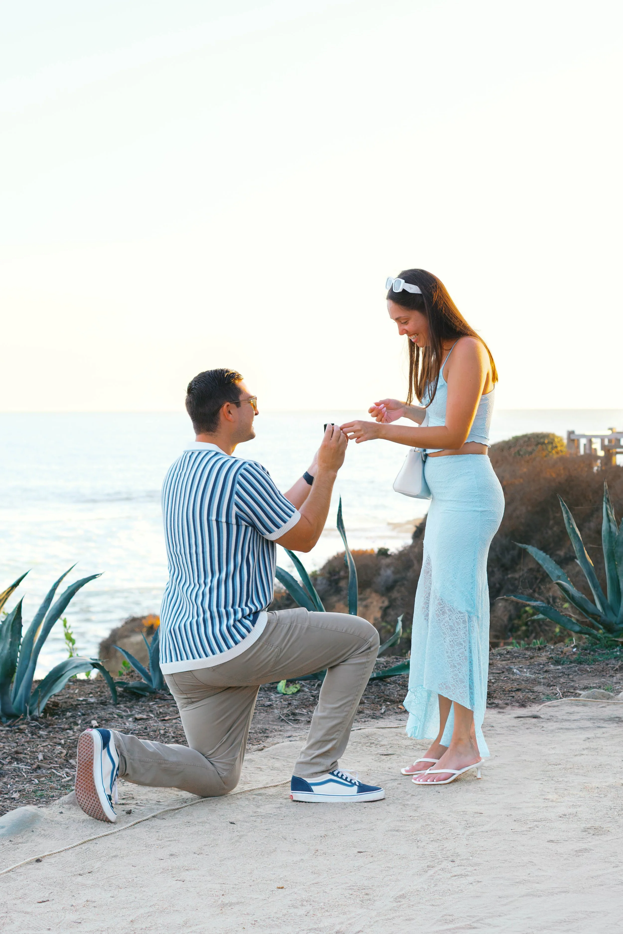 Sunset surprise proposal along the coastal path overlooking Treasure Island Beach in Laguna Beach, photographed by Alissa Noelle Photography.